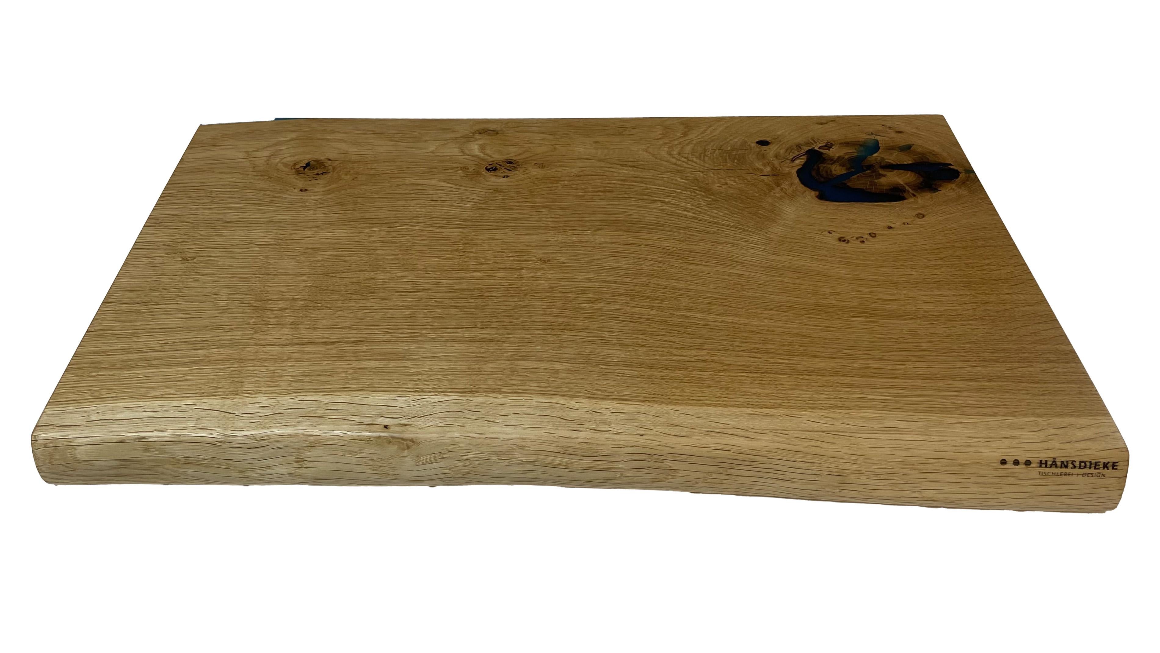 The oak cutting board was glued in multiple layers and cracks, knots, etc. were filled with high-quality epoxy. The surfaces are very finely sanded and sealed with oil. One edge has a rounding. The sides are straight and are ideal for bread and cuts