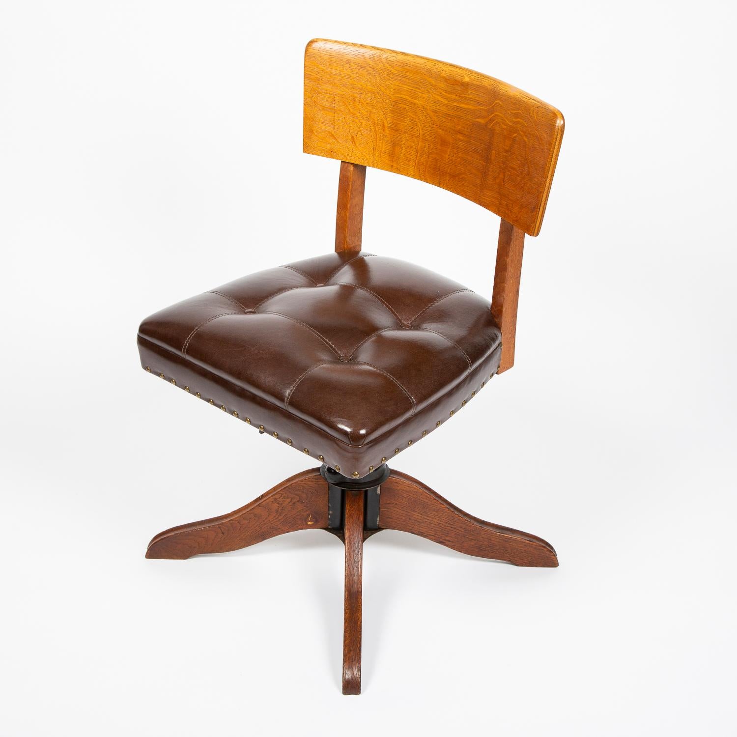 Oak desk chair with buttoned brown leather seat.

Adjustable with swivel seat.

SMV mark cast into metalwork.