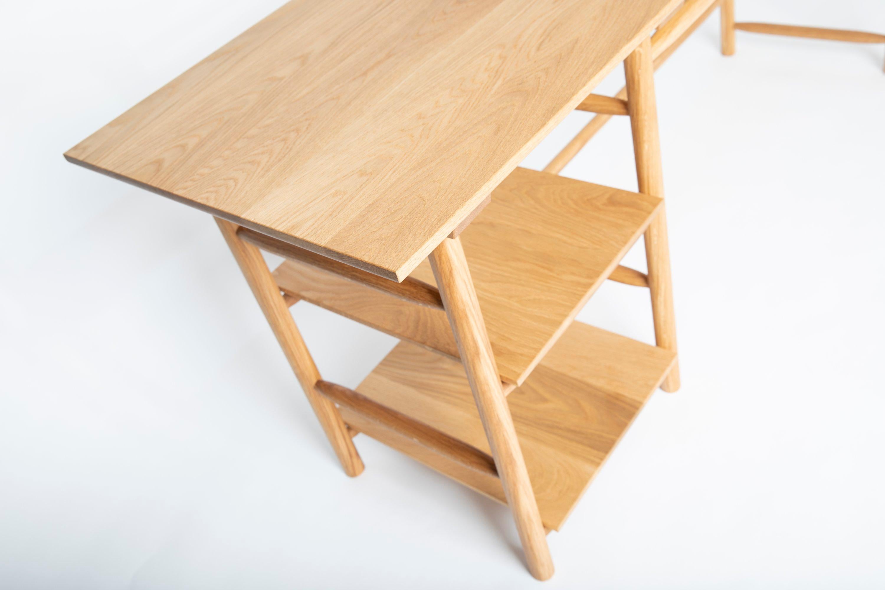 Präsentation eines handgefertigten Schreibtischs von Frank Buschmann  aus hochwertigem Eichenholz, veredelt mit einer exquisiten Öl-Wachs-Beschichtung für dauerhafte Schönheit. Jedes Element ist sorgfältig verarbeitet, wobei die Beine und Bänder mit
