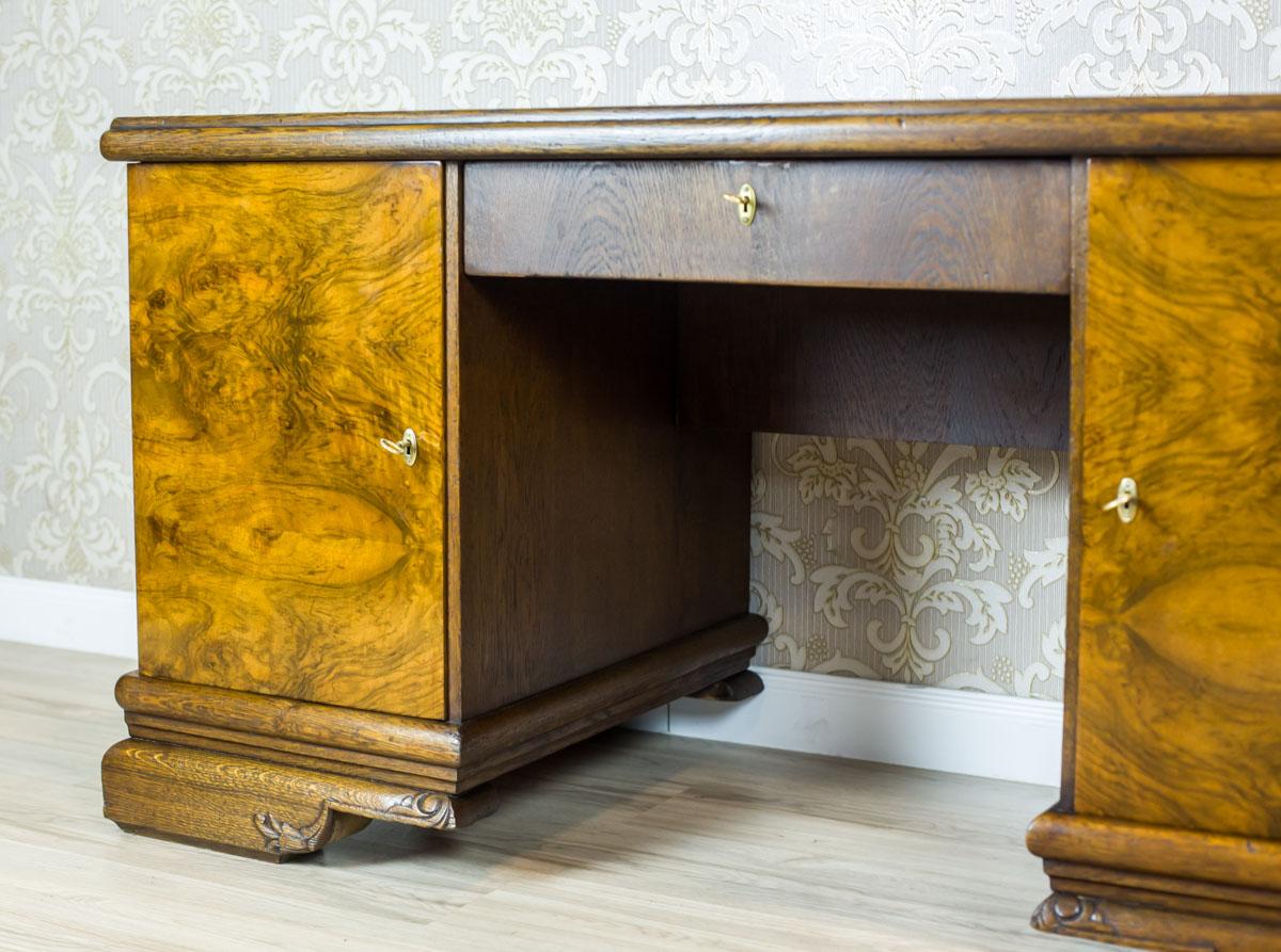 Oak Desk from the Interwar Period

We present you a solid desk from the Interwar Period, made of oak wood, with the door fronts covered with burl veneer.
This piece of furniture is composed of two chests that are divided with a drawer beneath the