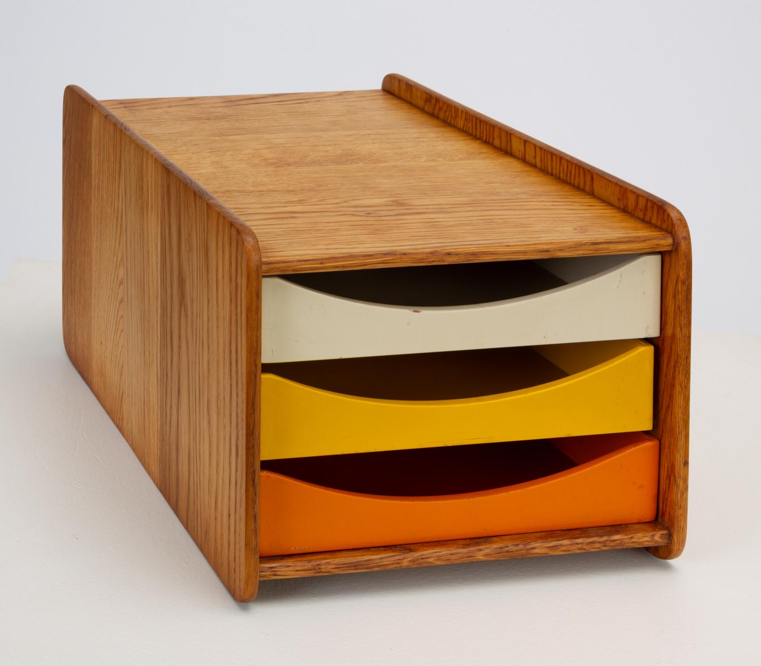 Danish-designed, Swedish-made desk organizer by Børge Mogensen for Karl Andersson & Söner from the late 1950s or early 1960s. The small box has a case of solid oak with rounded corners and raised edges. Three painted drawers in white, yellow, and