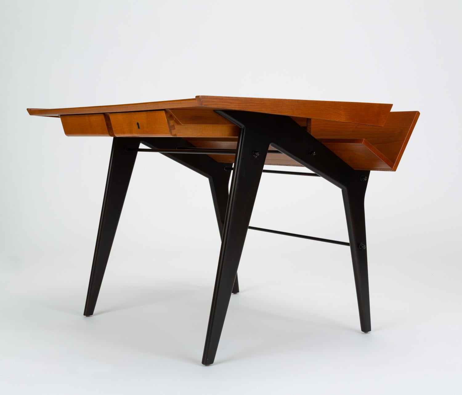 German modernist desk designed by Hartmut Lohmeyer in the 1960s and produced by Wilkhahn. This two-tone example is made of red oak, with ebonized legs. An ideal student desk or home office piece, the unique design features and angled shelf at the