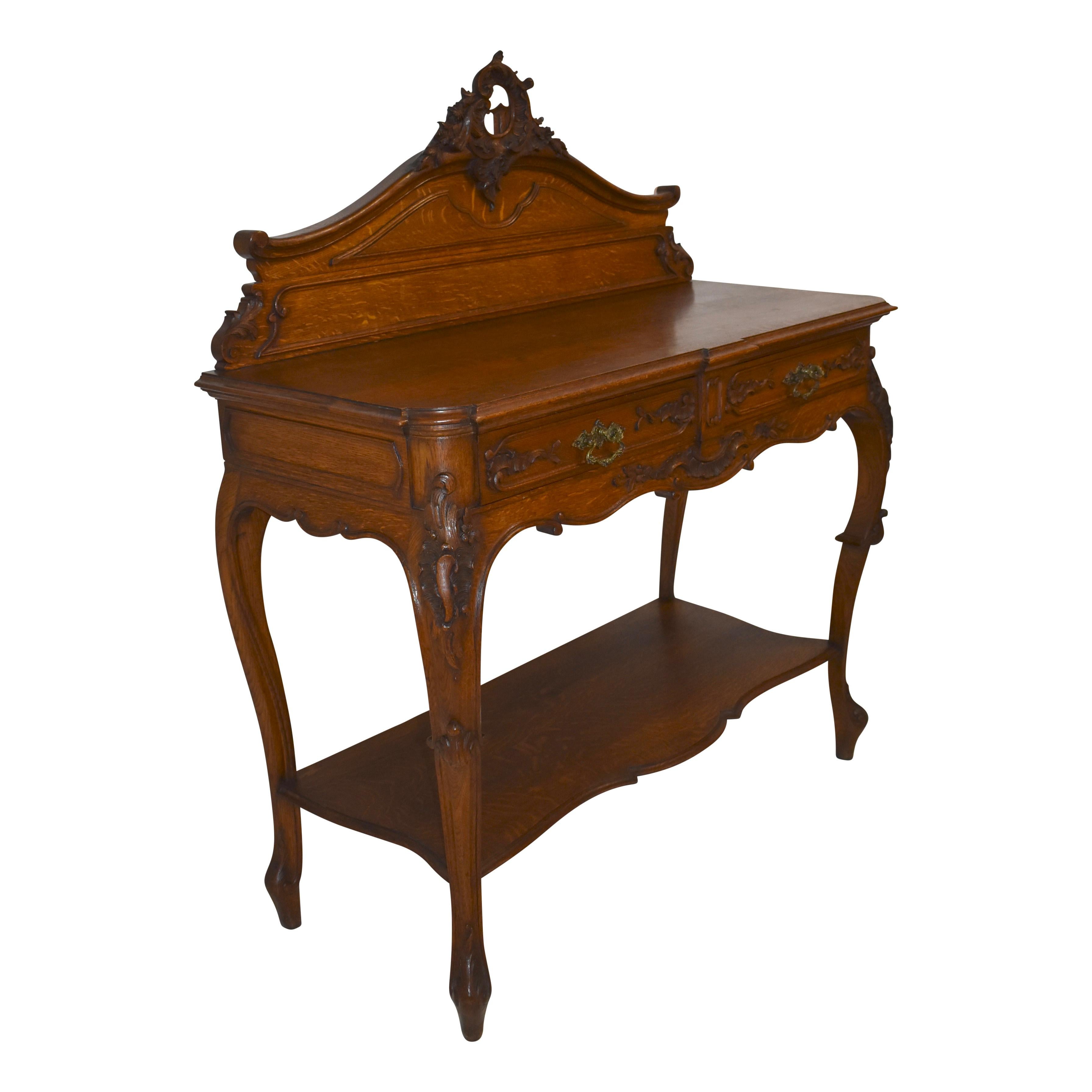 Beautifully carved from oak and quarter-sawn oak, this elegant dessert buffet features a pierced backboard carved of c scrolls, ruffles, flowers and foliage. Two dovetailed, carved drawers open to storage beneath the beveled top tier, which is 39.5