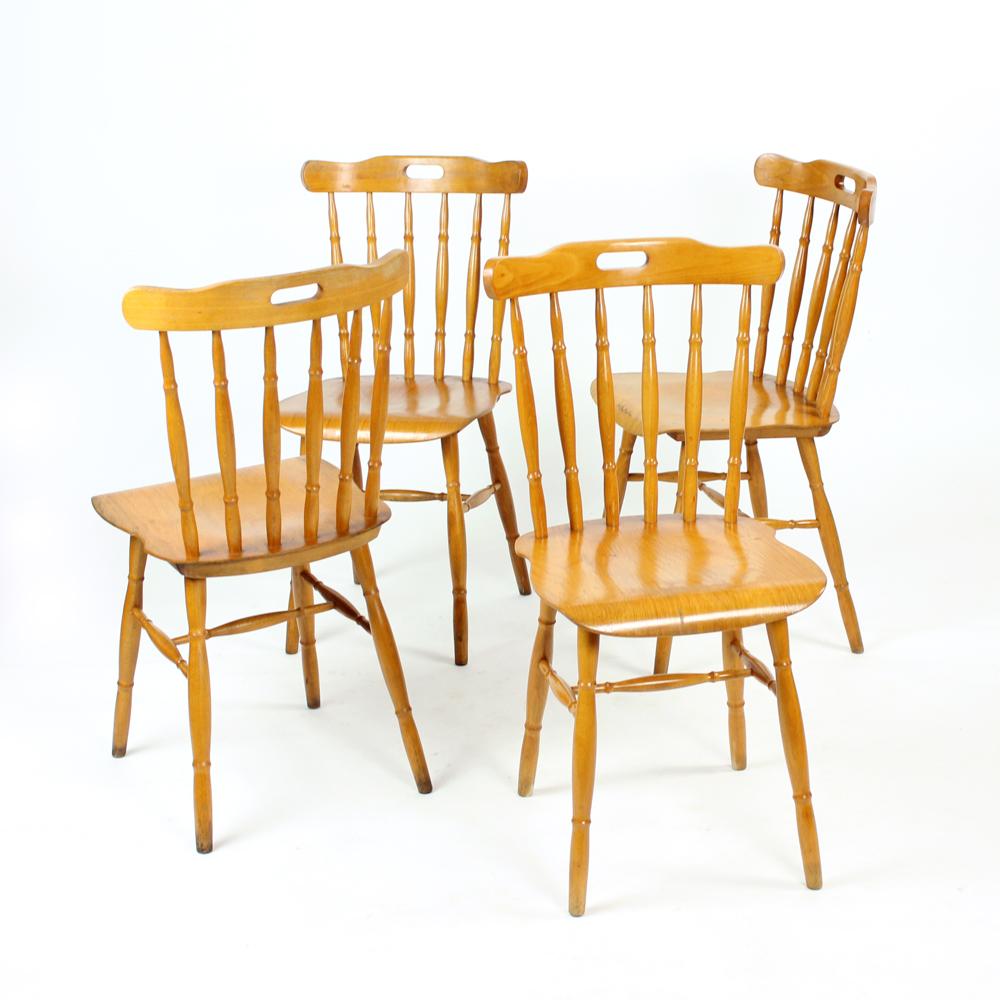 Beautiful set of four dining chairs made completely of wood. Carved details on the chairs made these chairs a stand out in any interior. The chairs have these carved wooden rods on the backrests and base. The seat is beautifully shaped with bent