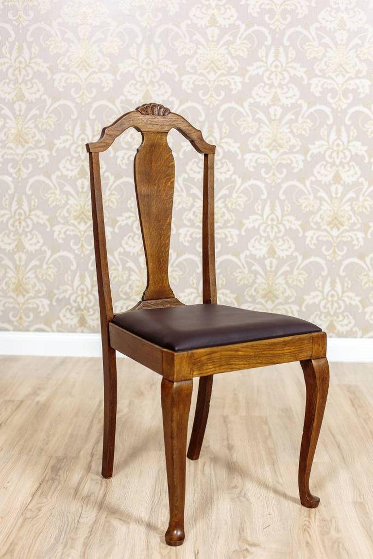 The suite includes 7 oak chairs with seats upholstered with natural leather.
The period of origin is dated the Interbellum.
The front legs of the chairs are cabriole bent. The top rails of the backrests are decorated with a stylized shell
