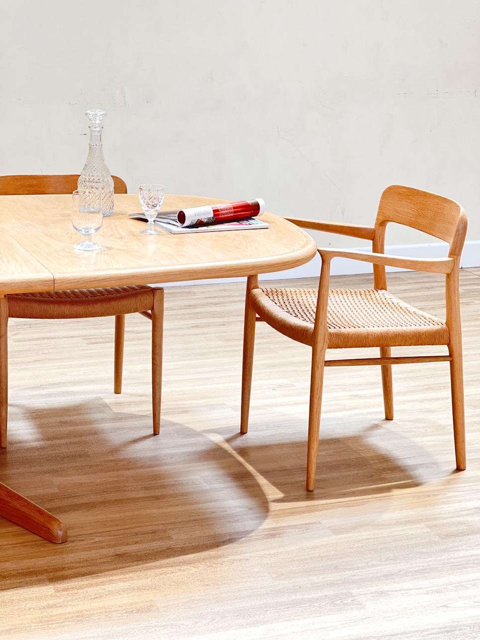 This set includes a long extending oak table, handcrafted in oak wood by the high-end cabinet maker Gudme møbelfabrik A/S in Gudme, Denmark. The table features an easy system that allows storing the two extensions in a specially designed space. It