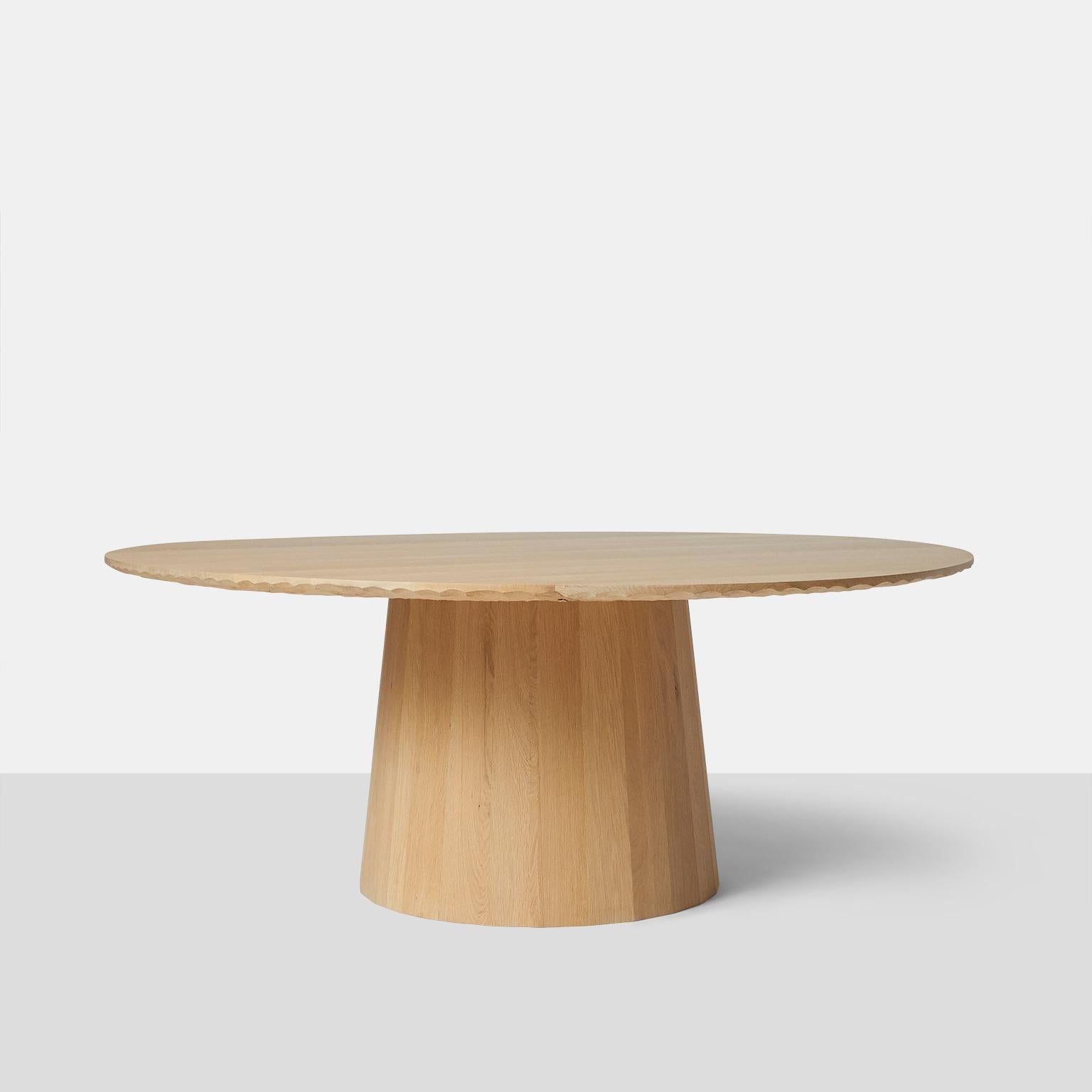 Oak dining table by Kaspar Hamacher
A large round dining table in oak completely handmade with hand scraped detail on edge and underside of tabletop. The base is made with wide planks and in a circular shape. Table will accommodate 10