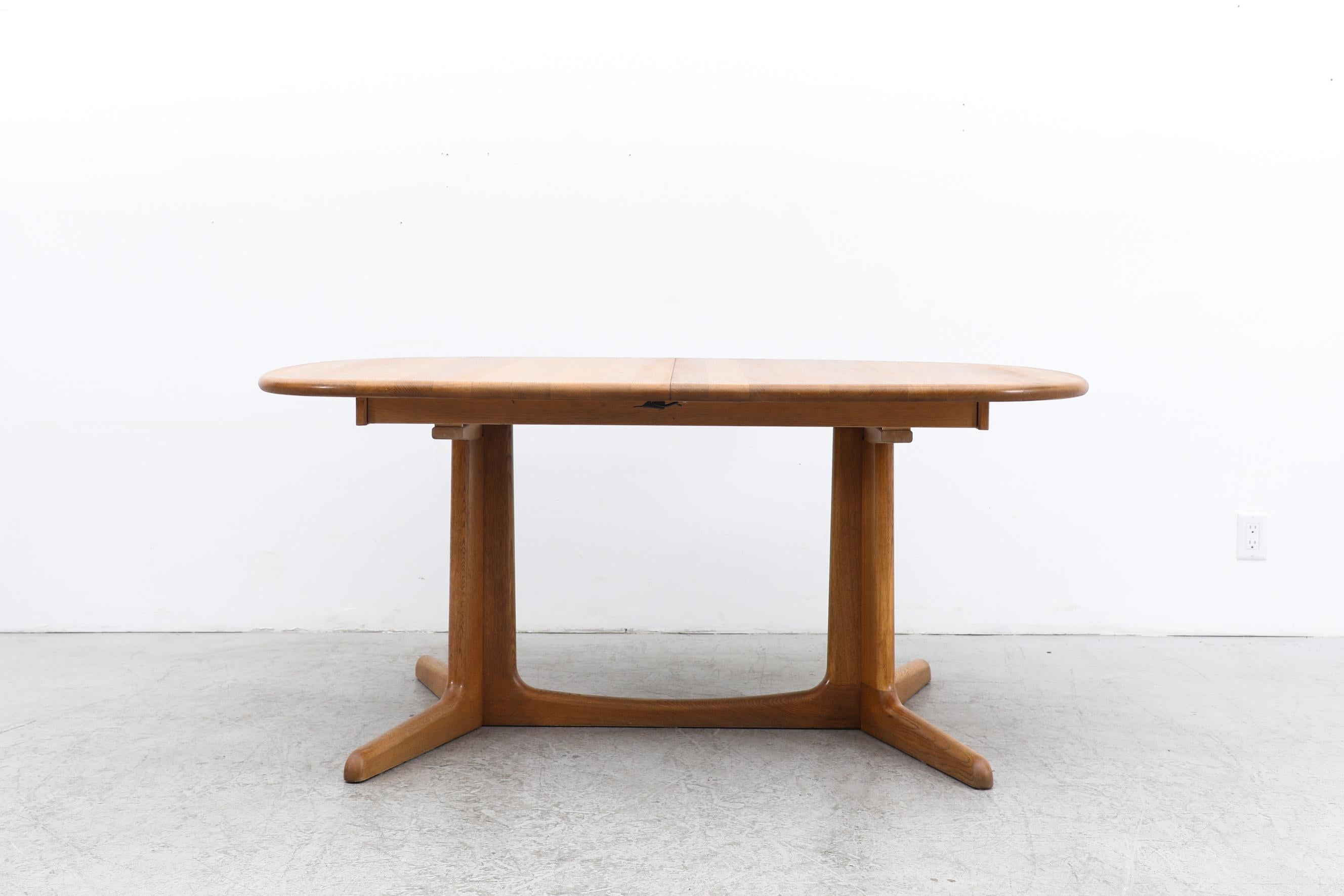 Oak dining table with a smooth rounded pedestal base and an extension leaf for Gudme Mobelfabrik, Denmark 1960's. With the leaf, it can fit up to 10 people and measures 102