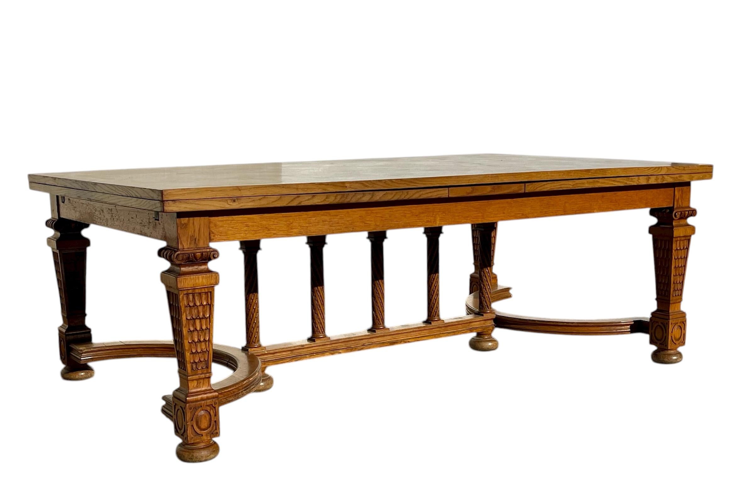 Mesa de comedor de roble claro con un bonito tablero de parqué. Esta mesa tiene dos hojas extensibles, una a cada lado, que se deslizan perfectamente bajo el tablero para abrirla fácil y cómodamente. Magnífica base con cuatro patas de balaustre