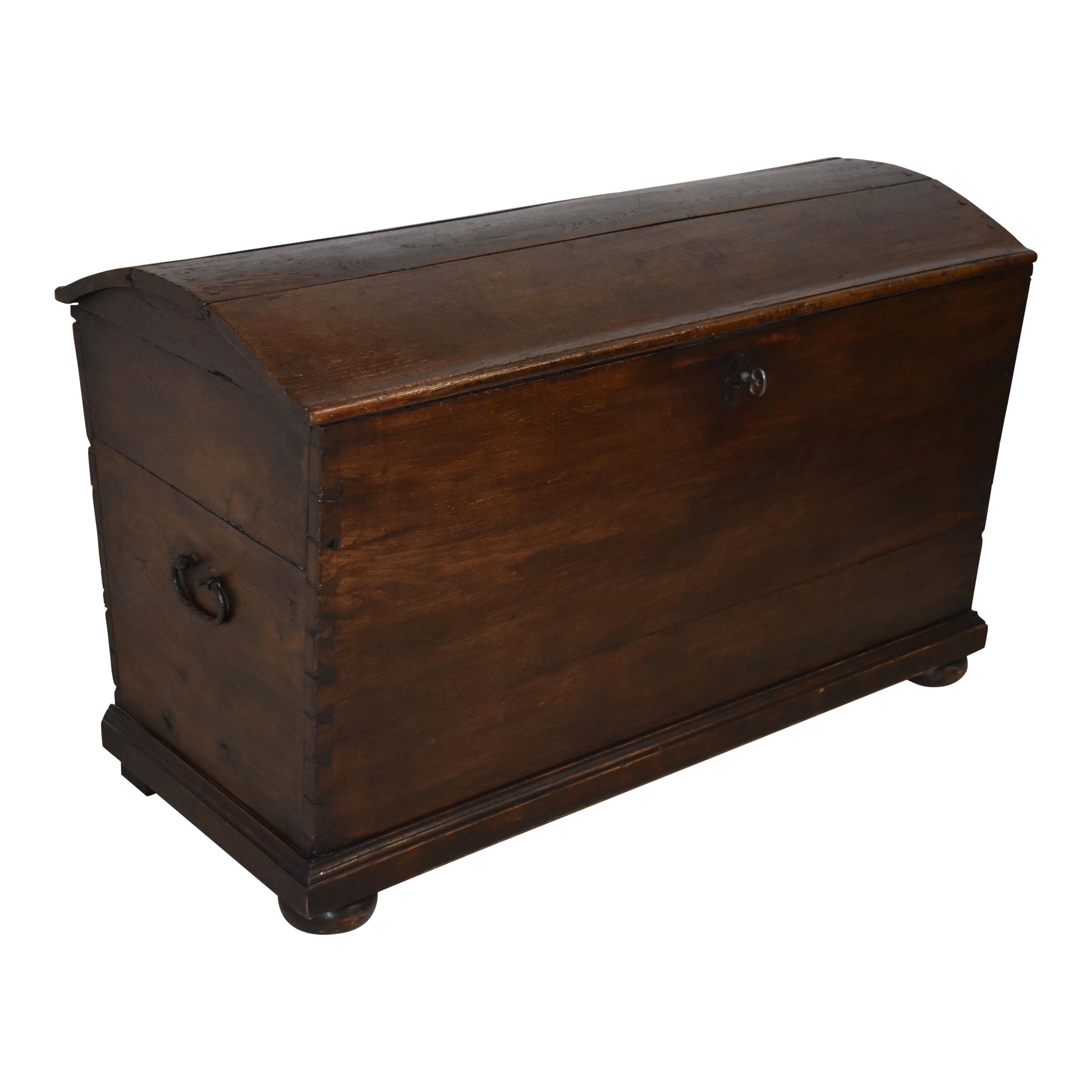 This dome-top, oak trunk from the mid-19th century features generous storage and a distinctive grain pattern that is not lost in the dark stain finish. Dovetail joinery at the corners and hand forged iron handles are evidence of the Fine