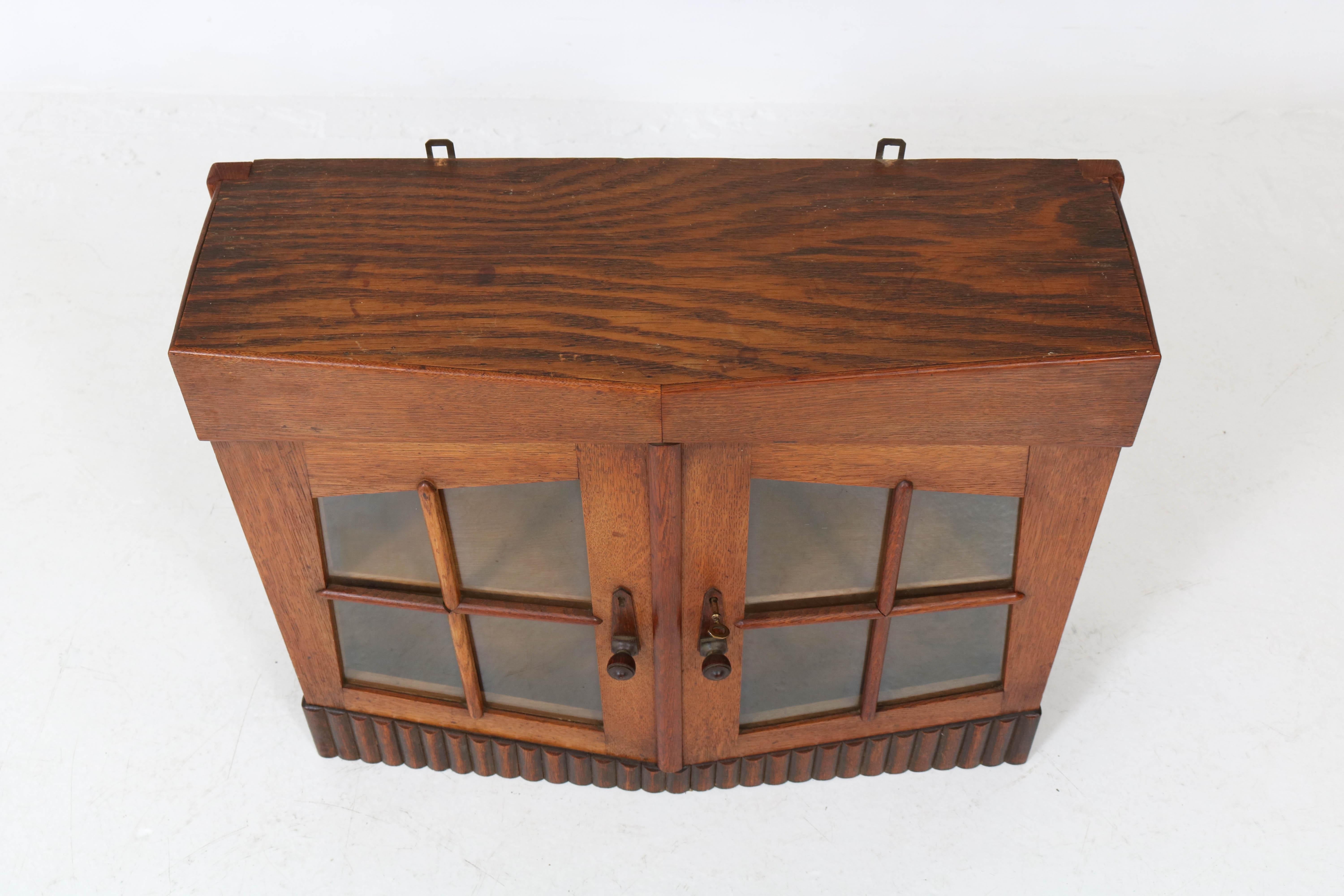 Stunning and rare Art deco Amsterdam School wall cabinet with glass doors.
Solid oak with original Macassar ebony handles.
Striking Dutch design from the twenties.
In good original condition with minor wear consistent with age and
