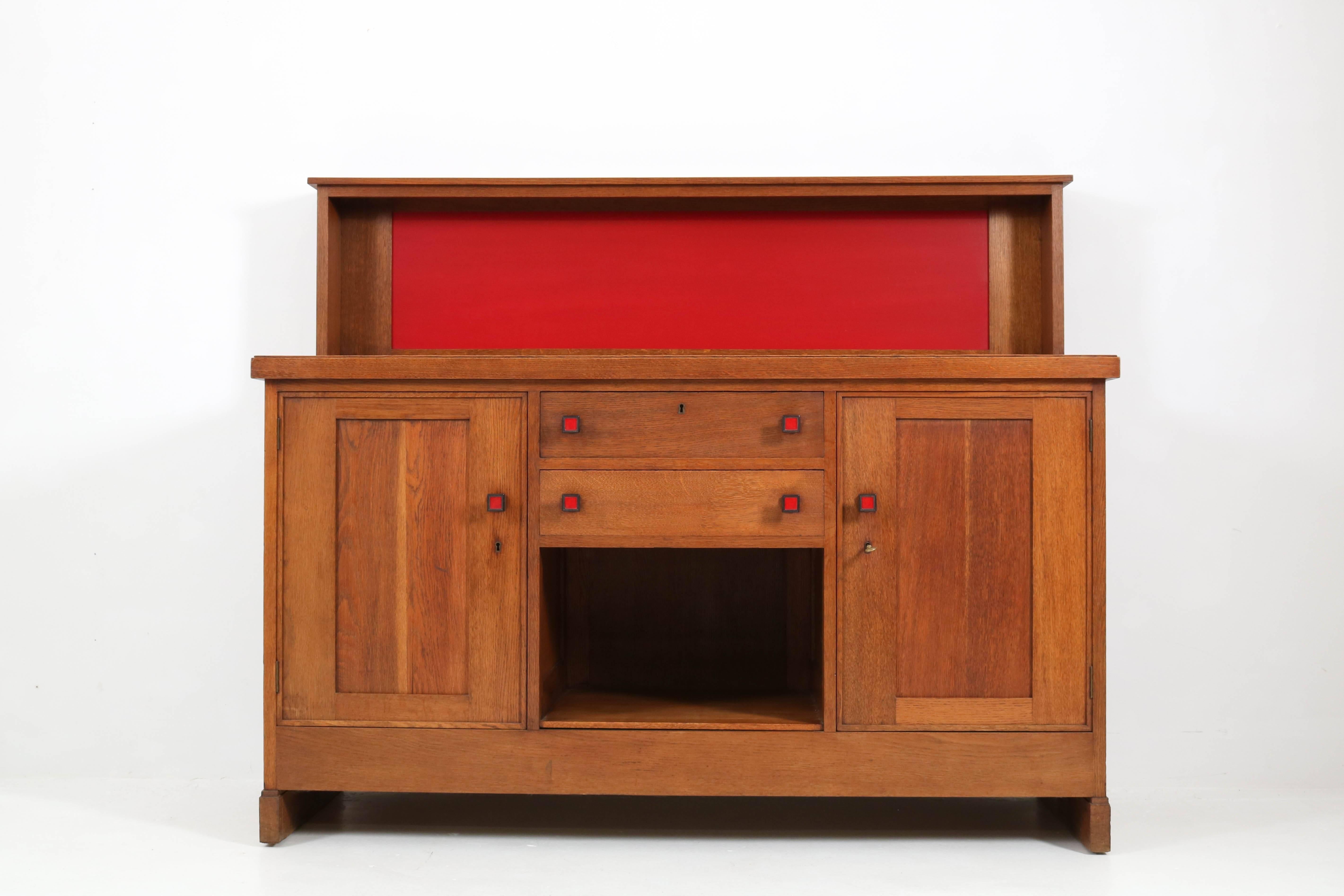 Stunning Dutch Art Deco Haagse School sideboard by Henk Wouda for Pander.
Solid oak with red lacquered details.
Original solid Macassar ebony knobs.
Striking Dutch design from the 1920s.
Marked with metal tag and brand mark and original key.
In