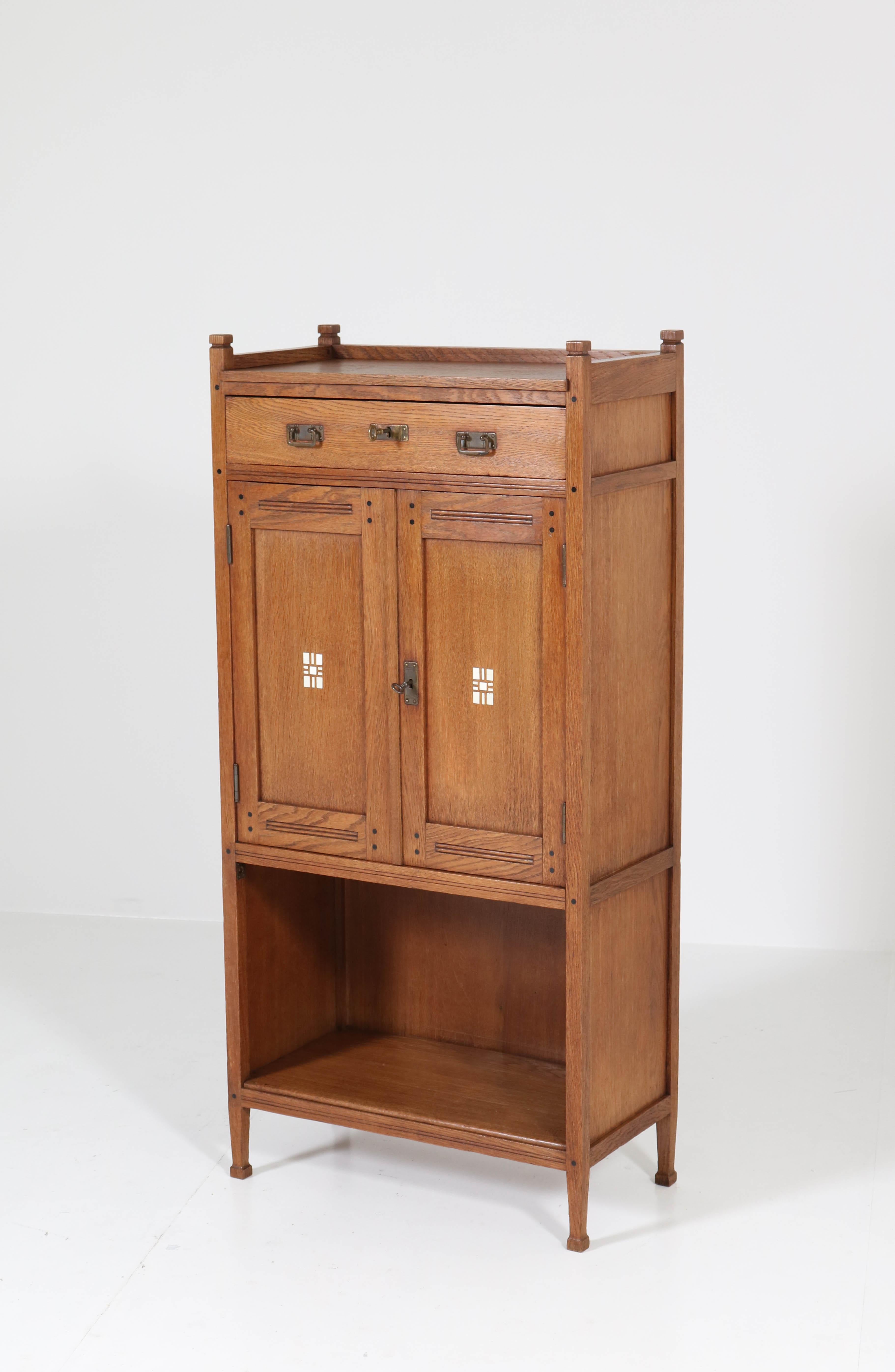 Wonderful and rare Art Nouveau Arts & Crafts cabinet.
Attributed to Karel Sluyterman for Onder den Sint Maarten.
Striking Dutch design from the 1900s.
Solid oak with original brass handles and original inlay.
In very good condition with minor