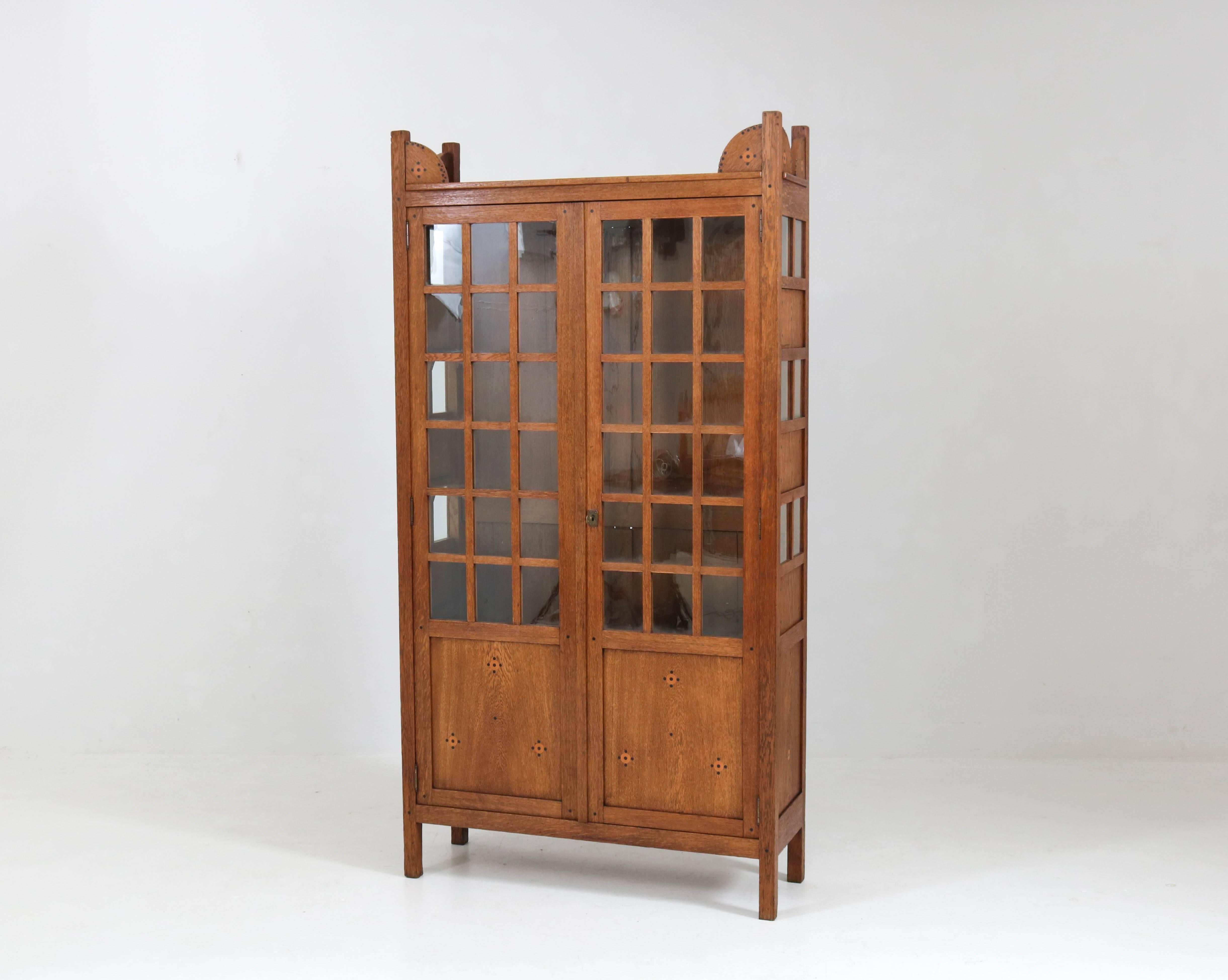 Offered by Amsterdam Modernism:
Rare and hard to find Art Nouveau Nieuwe Kunst bookcase by Jac van den Bosch.
Striking Dutch design from the 1900s.
Solid oak with original inlay and glass.
This elegant bookcase is not marked with tag 't Binnenhuis