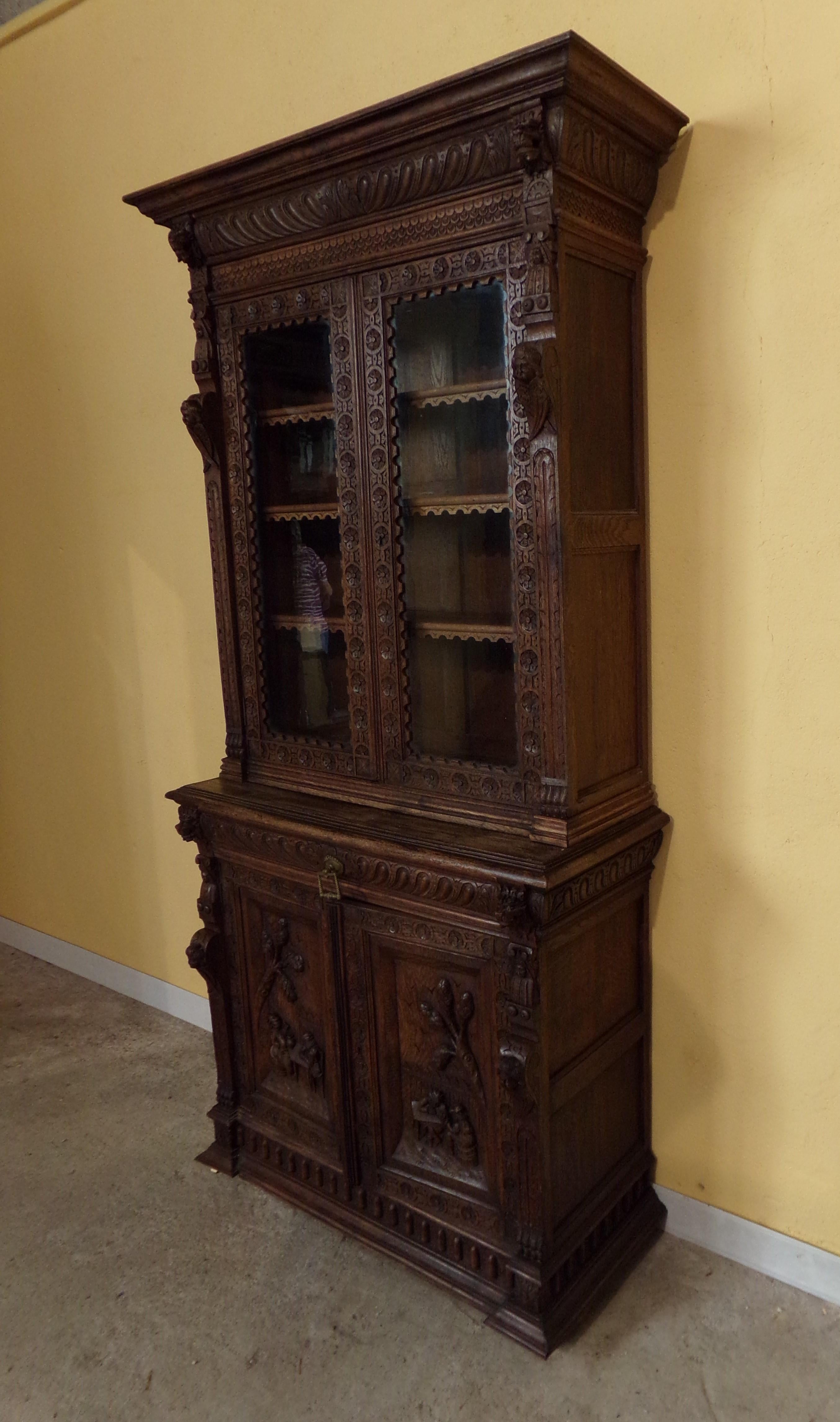 An unusual hand carved oak Dutch bookcase in the Renaissance Revival style C1880. Beautifully hand carve depicting Cherubs, traditional masks and figures drinking and revelling in an ale house!