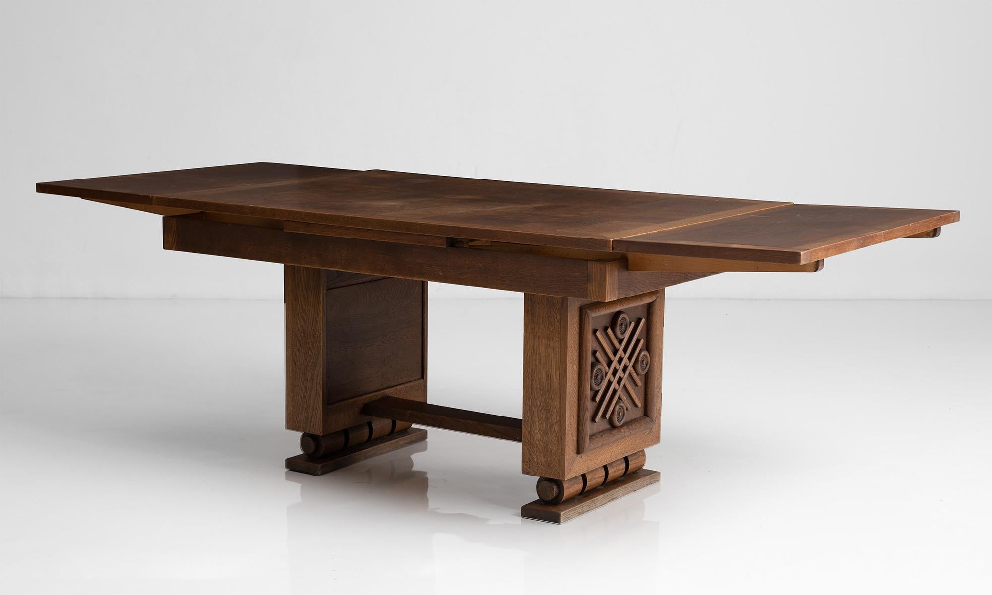 Oak extending dining table / desk.

France circa 1940

Art Deco table constructed in oak with marquetry top and decorative base.

Measures: 55” L / 89.75