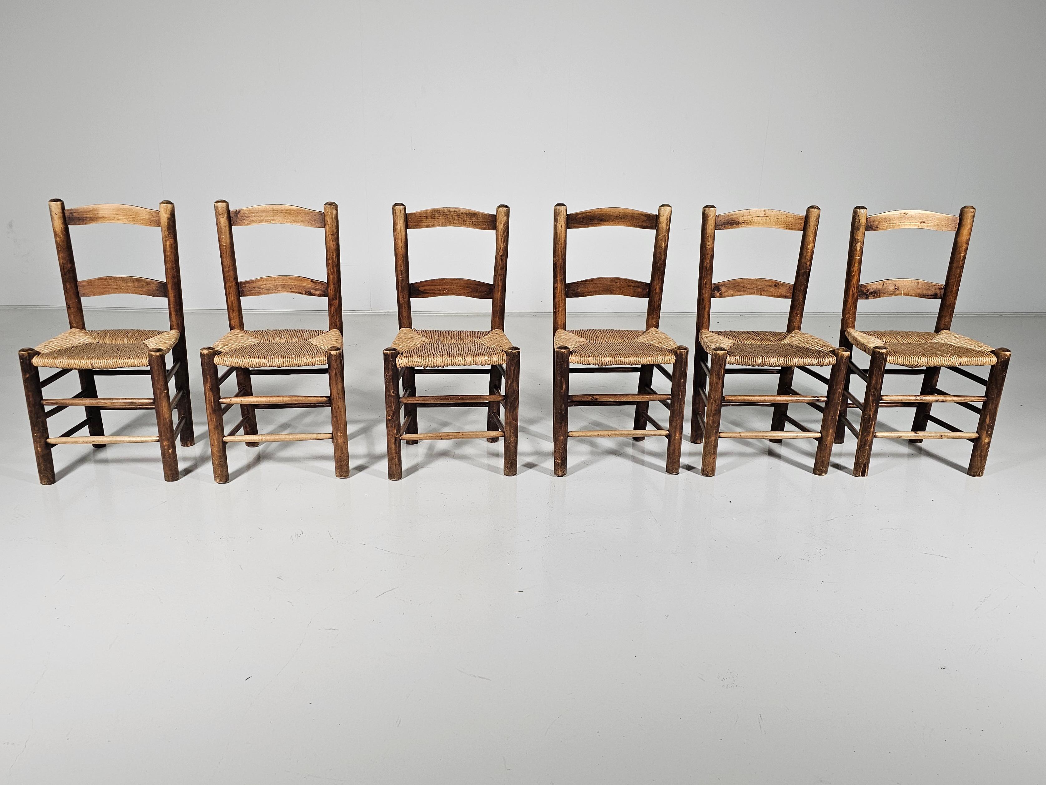 Set of 6 rustic farmer-style dining chairs made of oak with woven rush seats. made in Spain in the 1970s. The oak frames are in the original light-stained finish. The rush seats are original and in good condition.
 