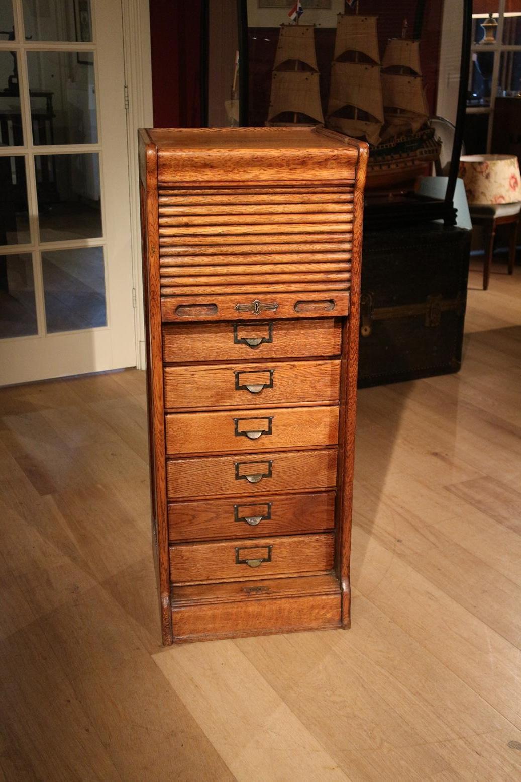 Antique oak filing cabinet with roller shutter and drawers behind it. Nice patina and good quality.
Origin: England
Period: Approx. 1920
Size: 44cm x 42cm x H 112cm
No lock.