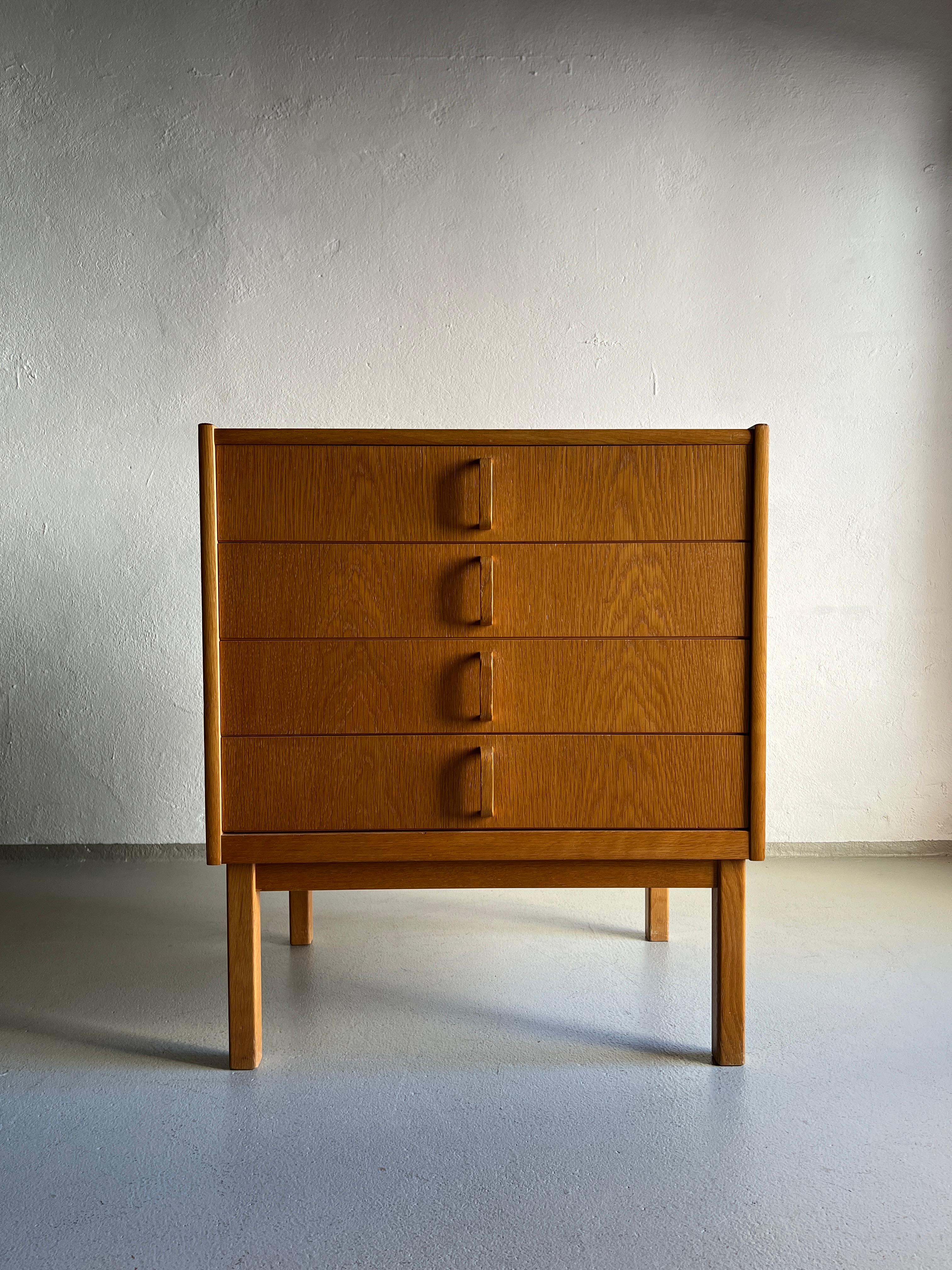 Vintage veneered oak chest of drawers with brass details on the sides and solid oak base. Each drawer features green laminated bottom.

Additional information:
Country of manufacture: Sweden
Design period: 1960s
Dimensions: 62 W x 45 D x 72 H