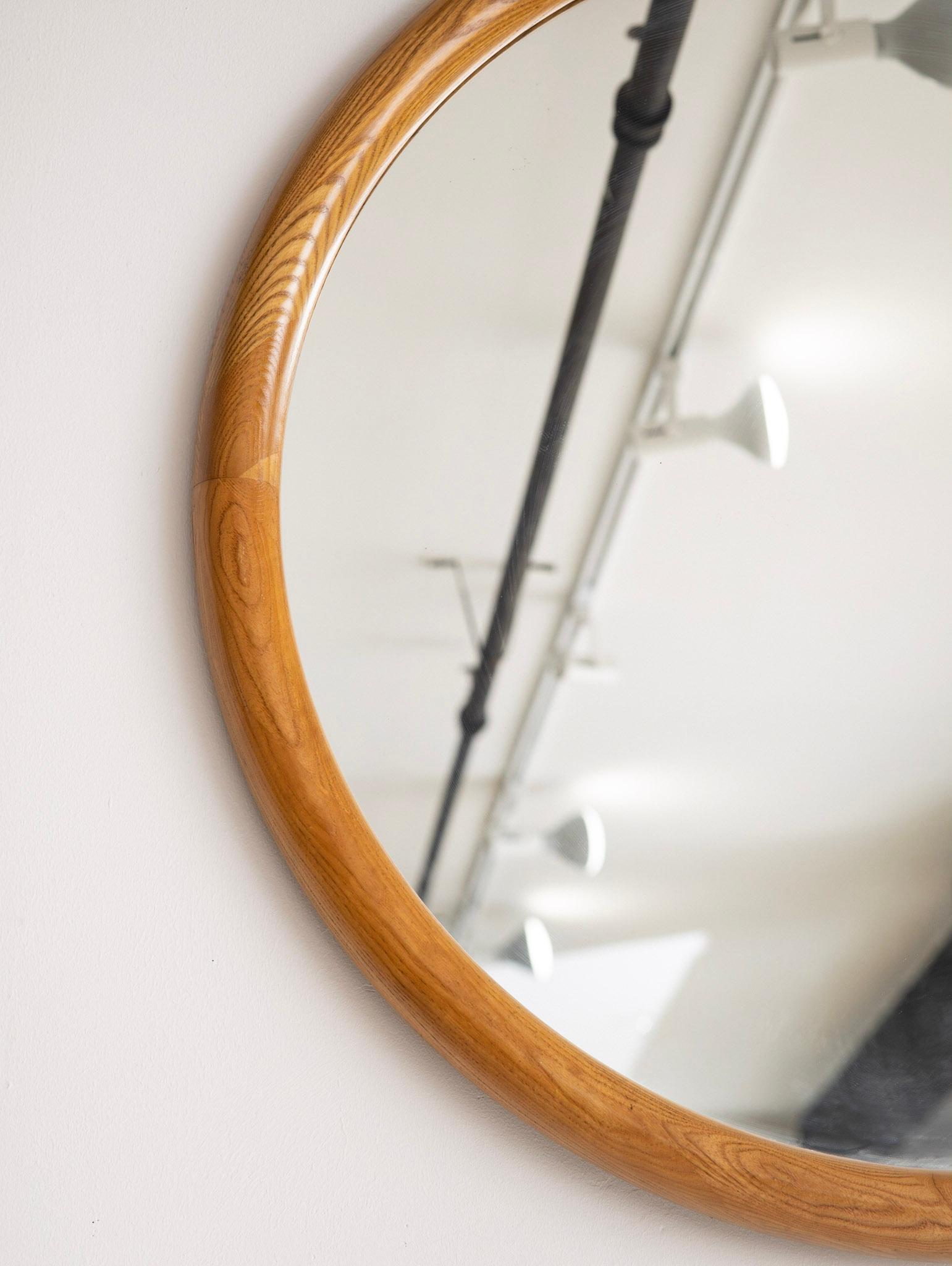 Large round wall mirror. Sculpted oak frame.