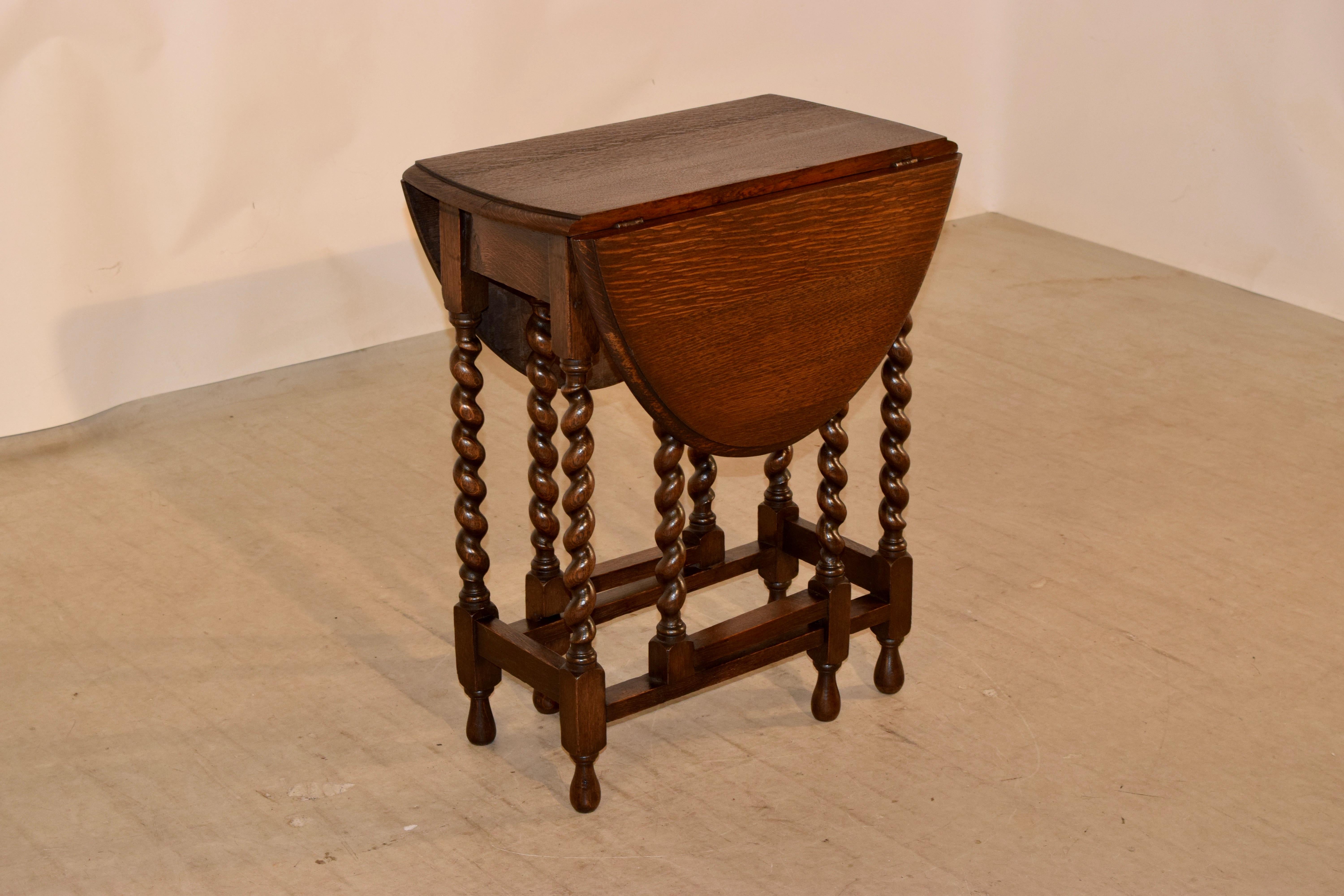 English oak gateleg table with a beveled edge around the top following down to a simple apron and supported on hand-turned barley twist legs, joined by simple stretchers, circa 1900. Raised on hand-turned feet. Top open measures 36.25 x 22.88.
 
