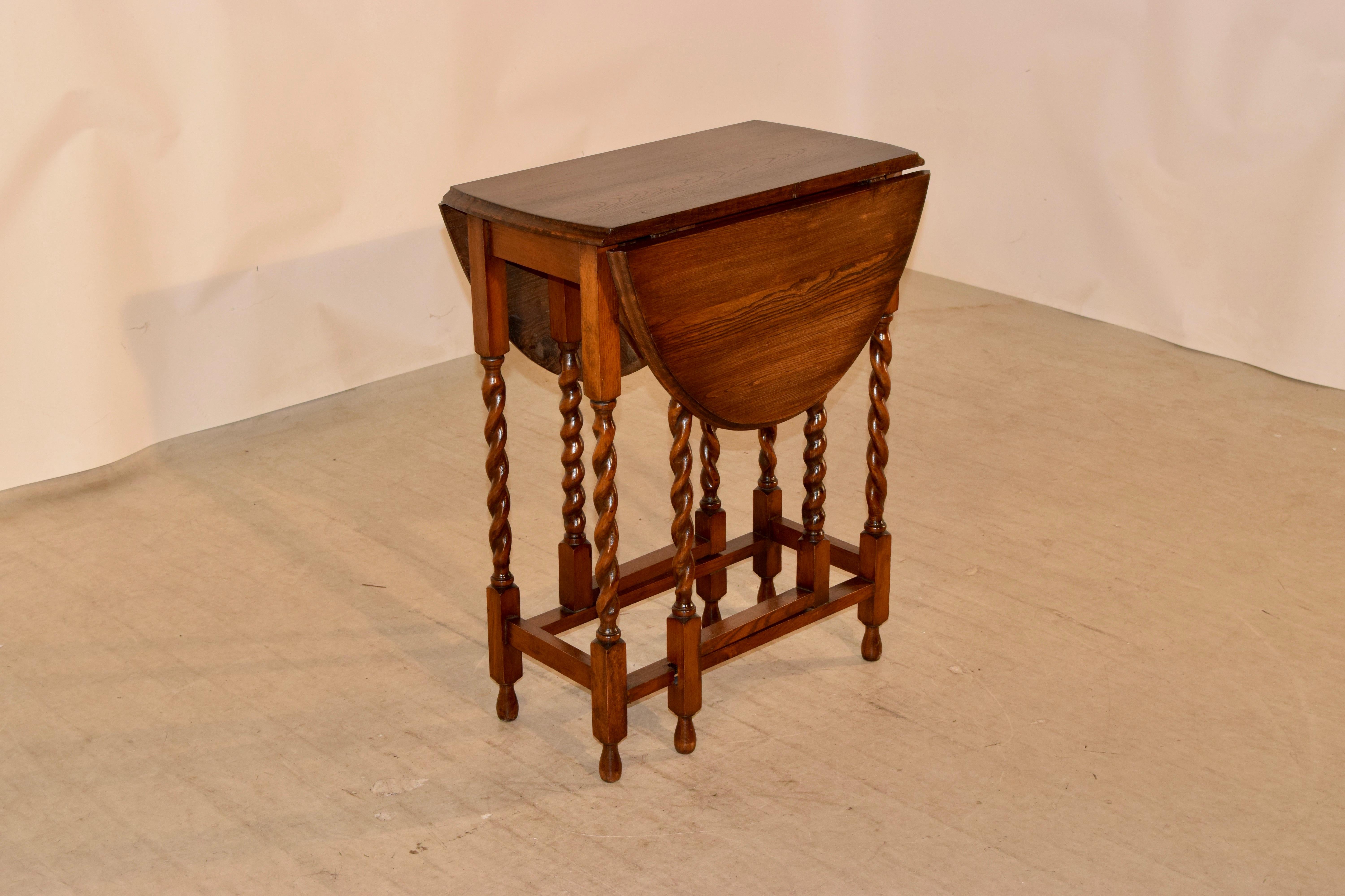 English oak gateleg table with a beveled edge around the top following down to a simple apron and supported on hand-turned barley twist legs, joined by simple stretchers, circa 1900. Raised on hand-turned feet. Top open measures 35.13 x 23.5.