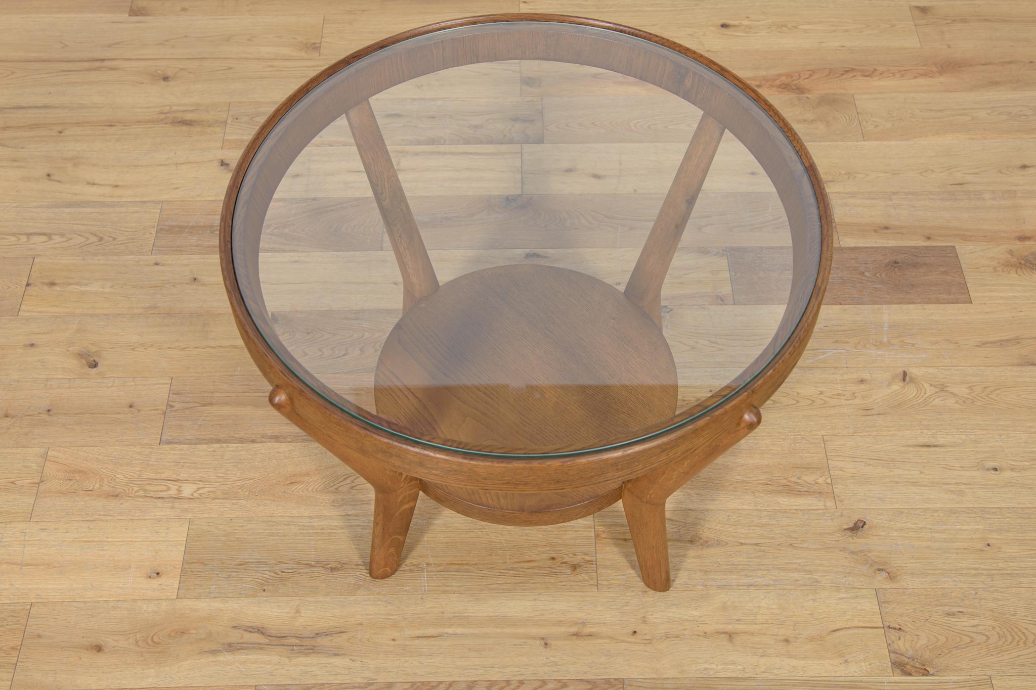 A round coffee table designed by architect duo K. Kozelka & A. Kropacek in 1944. Produced by Interier Praha in the 40's. The design won second place at the Triennale in Milan in 1946. Light oak wood frame with the glass table top. The oak frame has