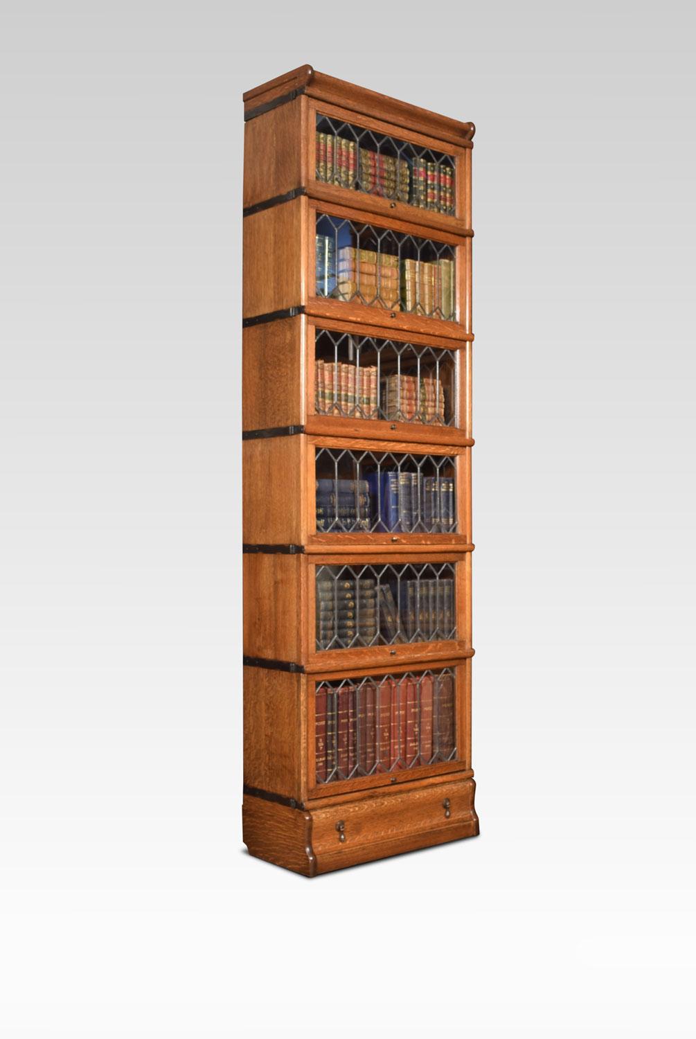 Oak six section bookcase, the molded top above six sections fitted with leaded glazed doors. All raised up on a plinth base with single long draw.
Dimensions:
Height 84 Inches
Width 24.5 Inches
Depth 12.5 Inches.