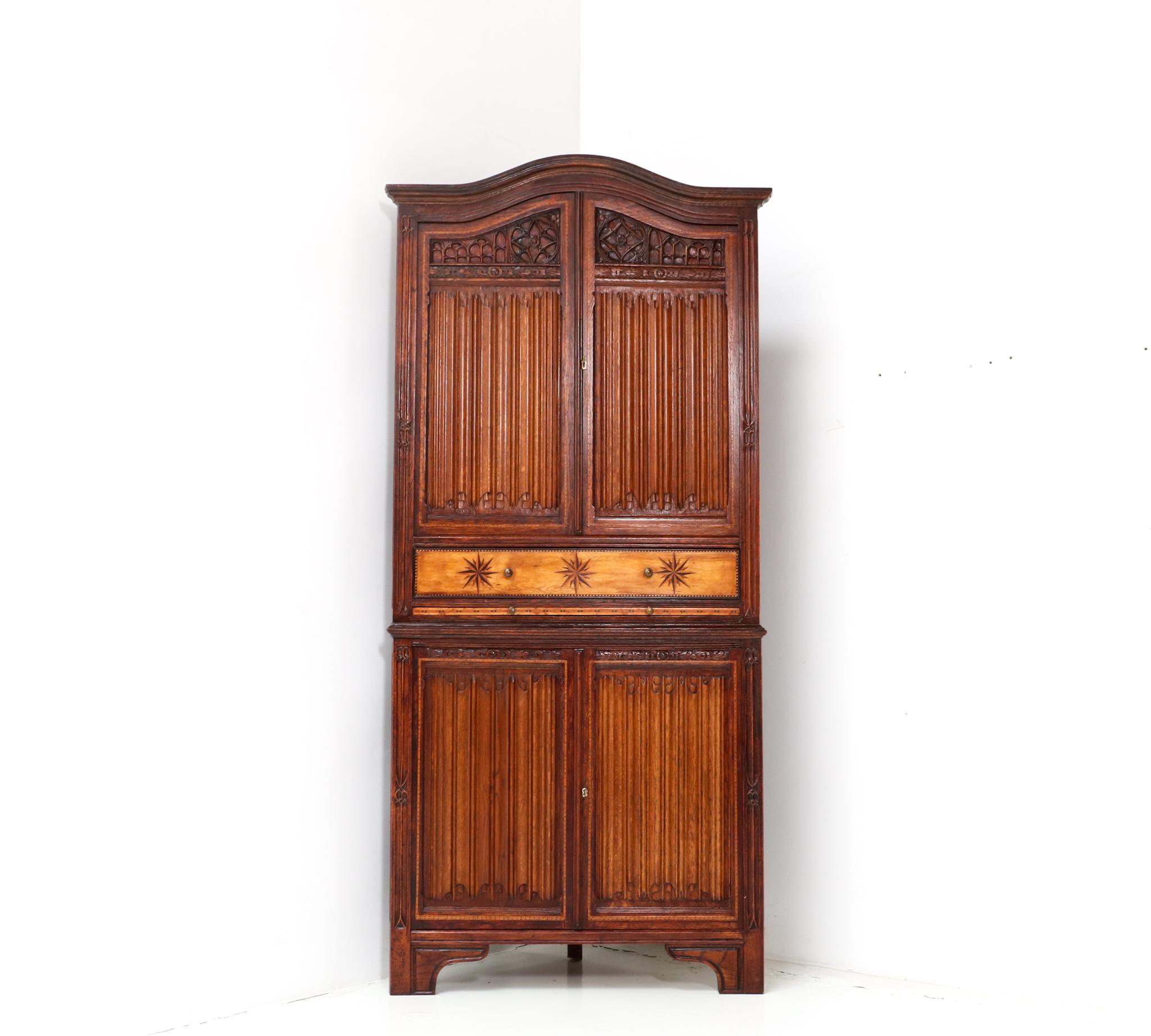 Magnificent and rare Gothic Revival corner cupboard.
Striking Dutch design from the 1960s.
Solid oak with original drawer with inlay.
Original pull out shelf.
This wonderful Gothic Revival corner cupboard comes in two pieces for easy