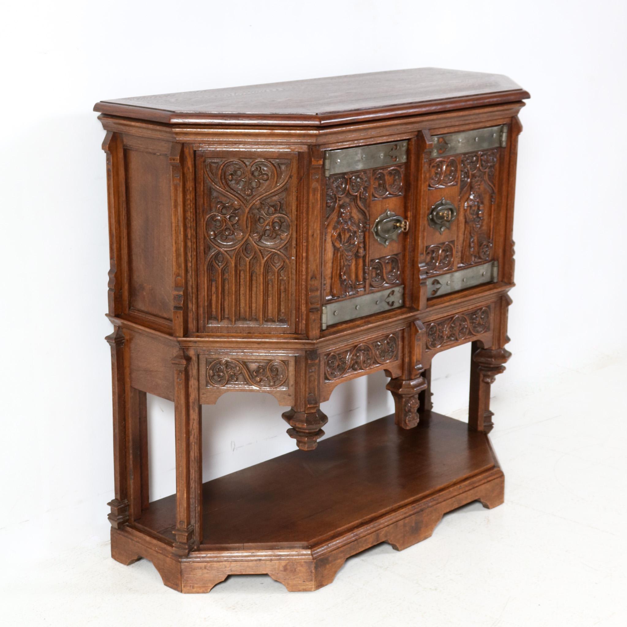 Stunning and rare Gothic Revival credenza.
Striking Dutch design from the 1930s.
Solid oak with original hand-carved decorative panels.
Original wrought iron handles and hinges.
The top of solid oak  has been refinished.
Two original drawers with