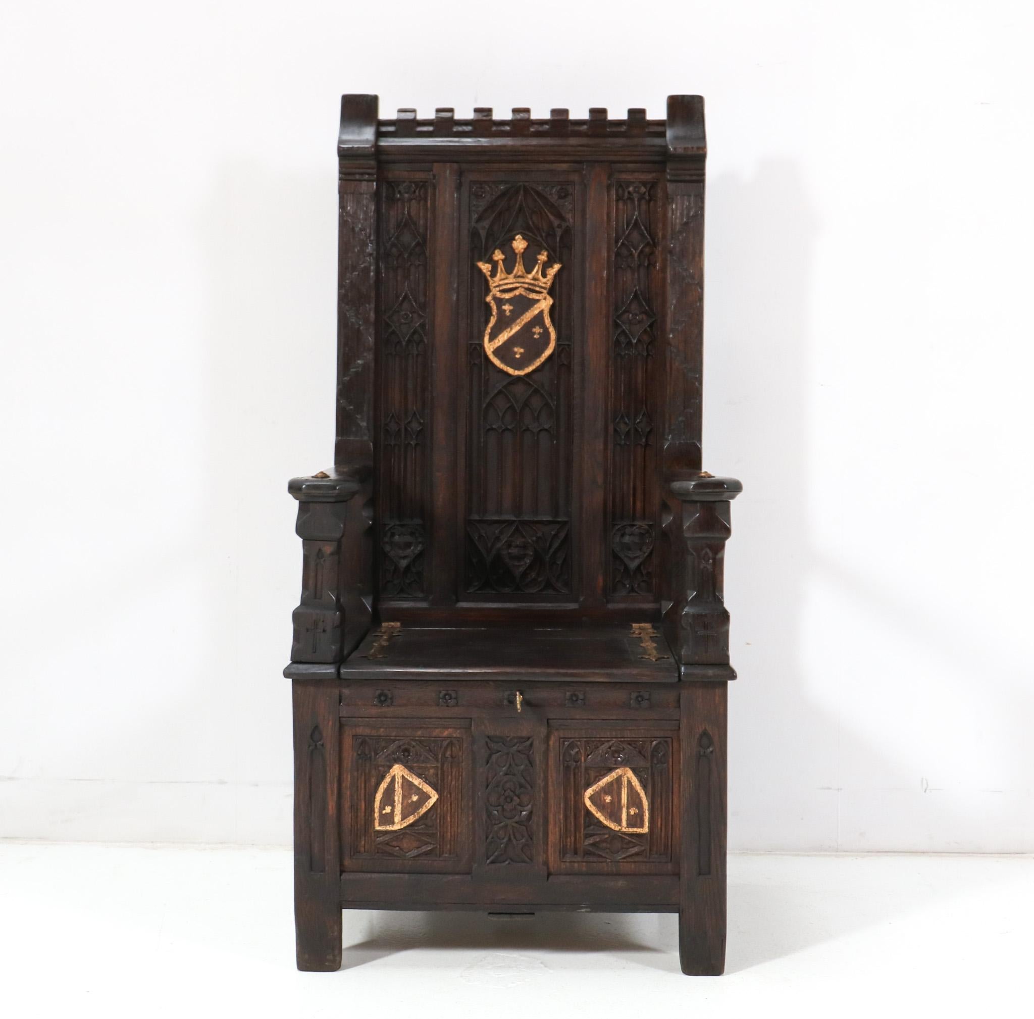Amazing and rare Gothic Revival throne chair.
Striking Dutch design from the 1900s.
Solid oak high back Bishop's throne chair with original hand-carved elements and gilt coat of arms.
The seat can be opened for storage and can locked also with