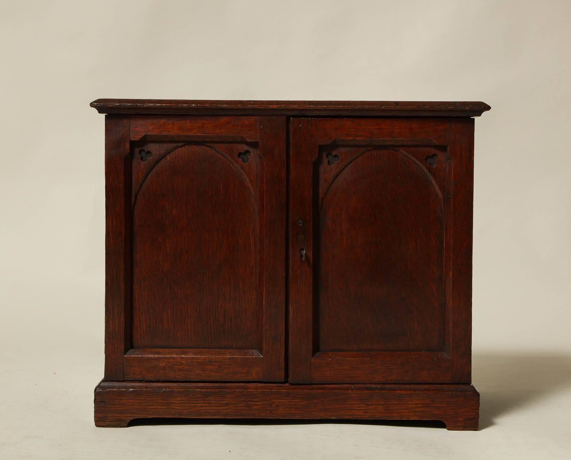 Fine 19th century English oak specimen or collectors cabinet having two panel doors with fretted gothic corners, the interior with five graduated drawers, the whole with good pleasing color and useful as a side table next to a chair or sofa, as well