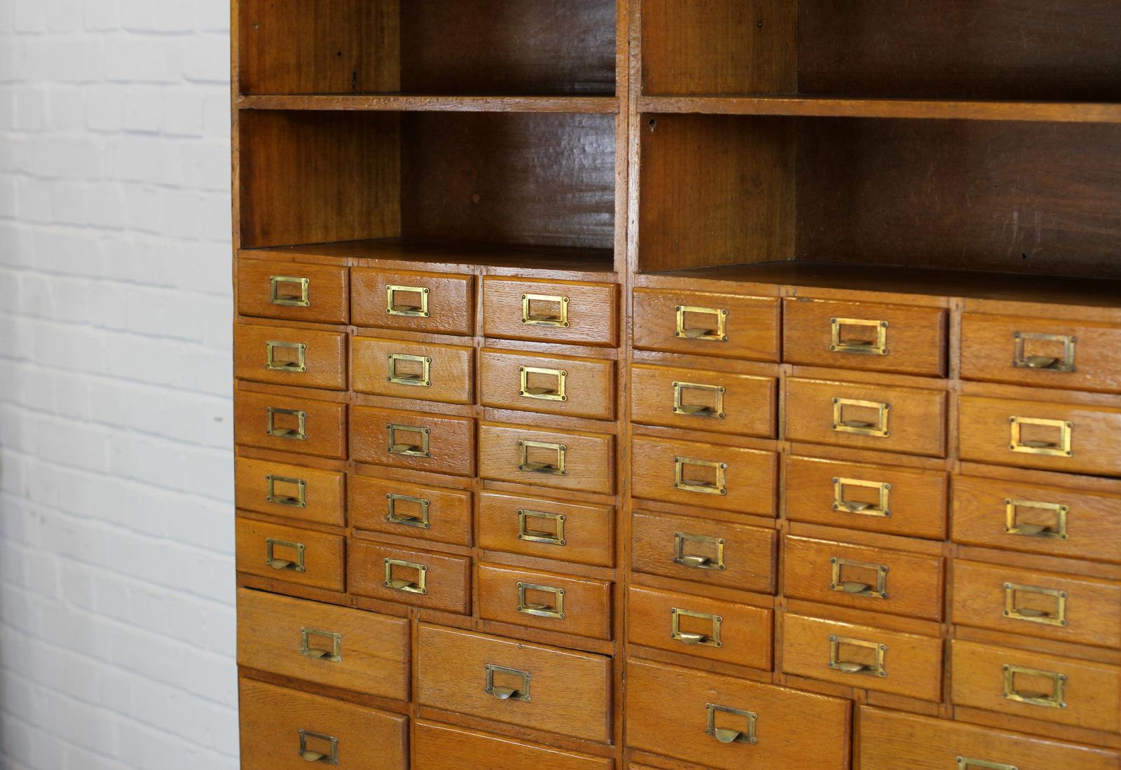 Oak Haberdashery cabinet, circa 1930s. 

- 50 various drawer sizes 
- Original brass pull handles with card holders
- 4 shelves
- Originally used to store and display buttons
- English, circa 1930s
- 122cm wide x 30cm deep x 196cm