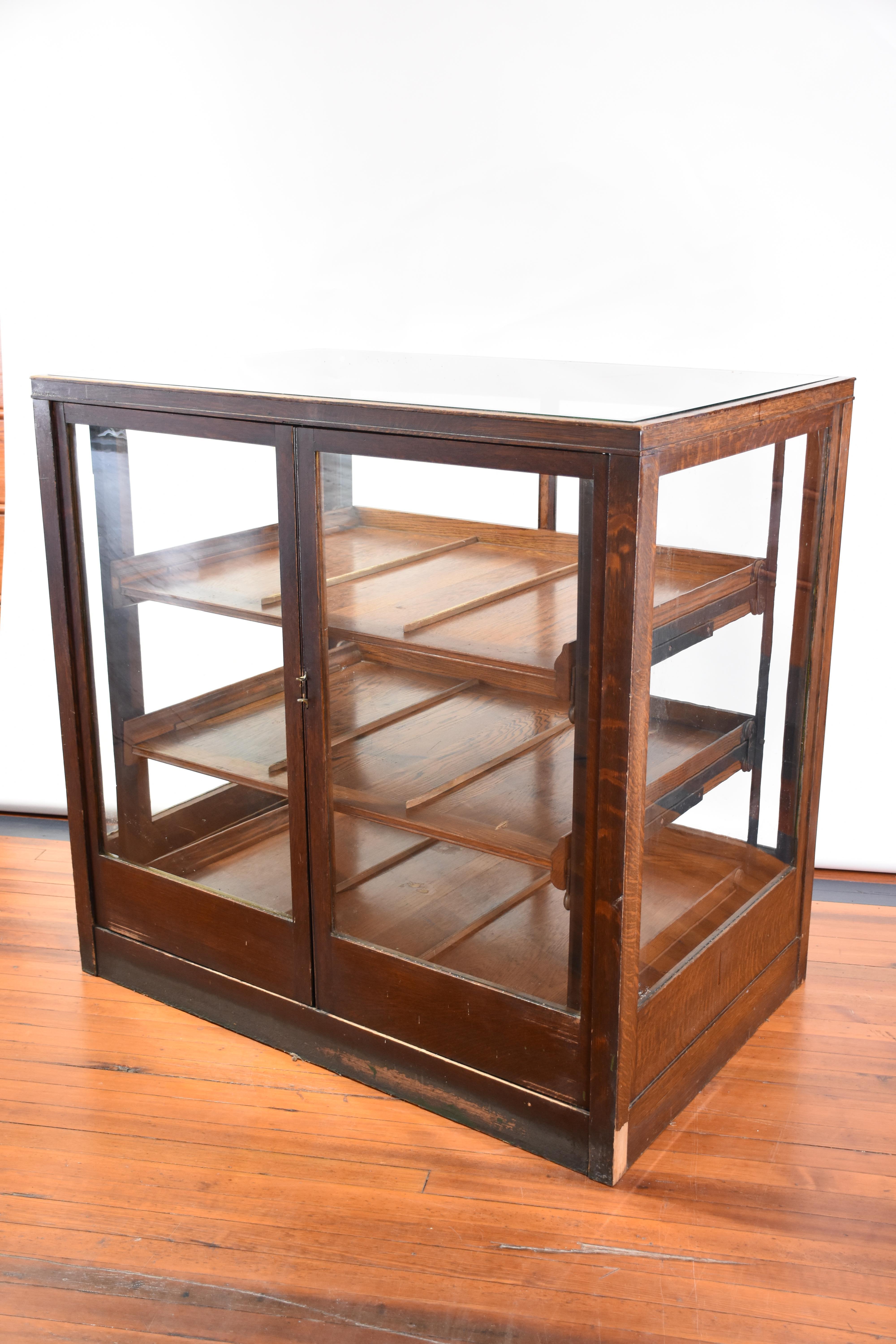 Dieser Kurzwarenschrank aus dem späten 19. Jahrhundert ist aus massiver Eiche gefertigt und weist eine reiche, warme Patina auf, die seine zeitlose Anziehungskraft und feine Handwerkskunst unterstreicht. Der Schrank ist mit zwei gerahmten Glastüren