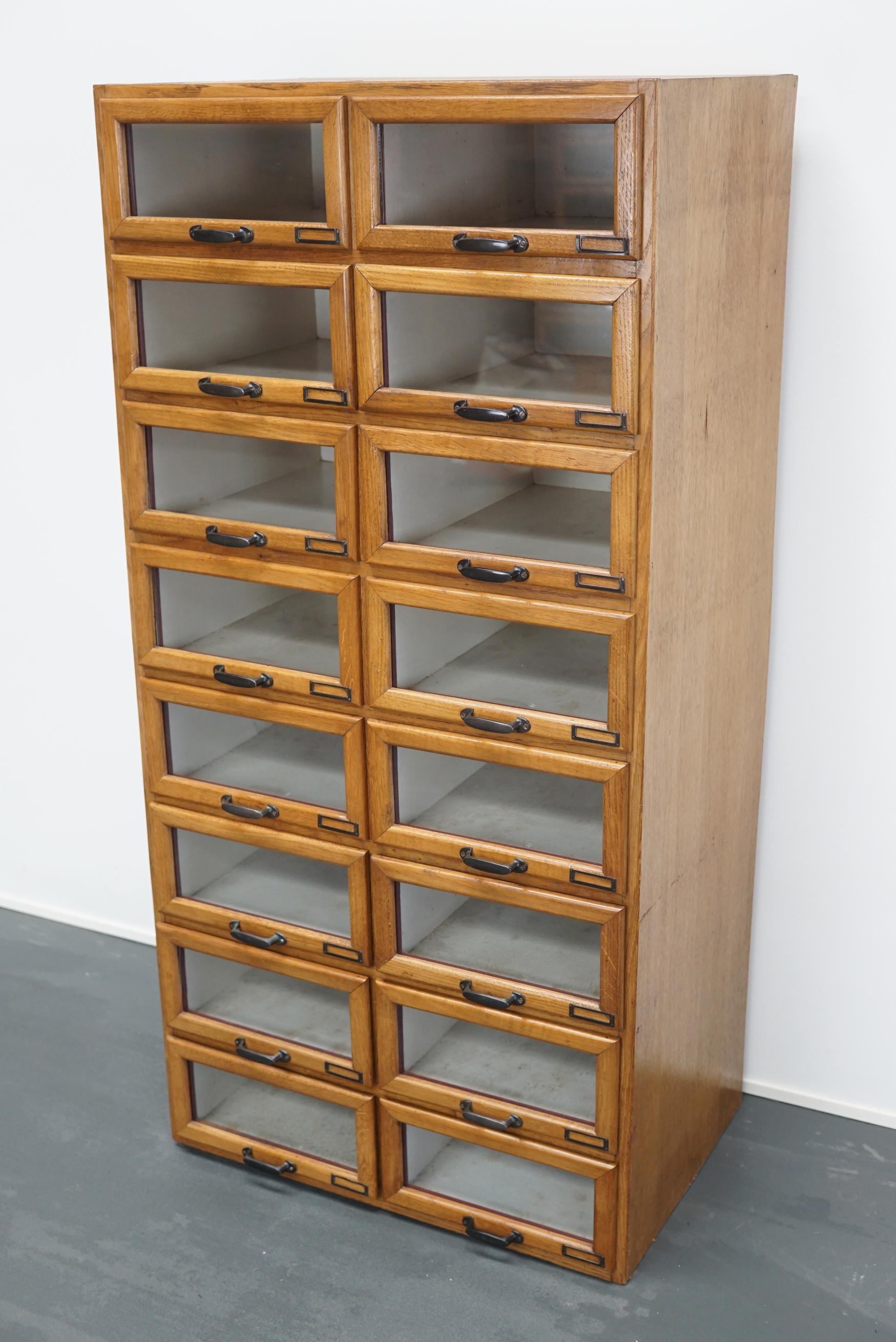 This vintage haberdashery shop cabinet originates from the Netherlands. The piece is made from oak and features 16 drawers which measure 42 x 30 x 14 cm on the inside.
