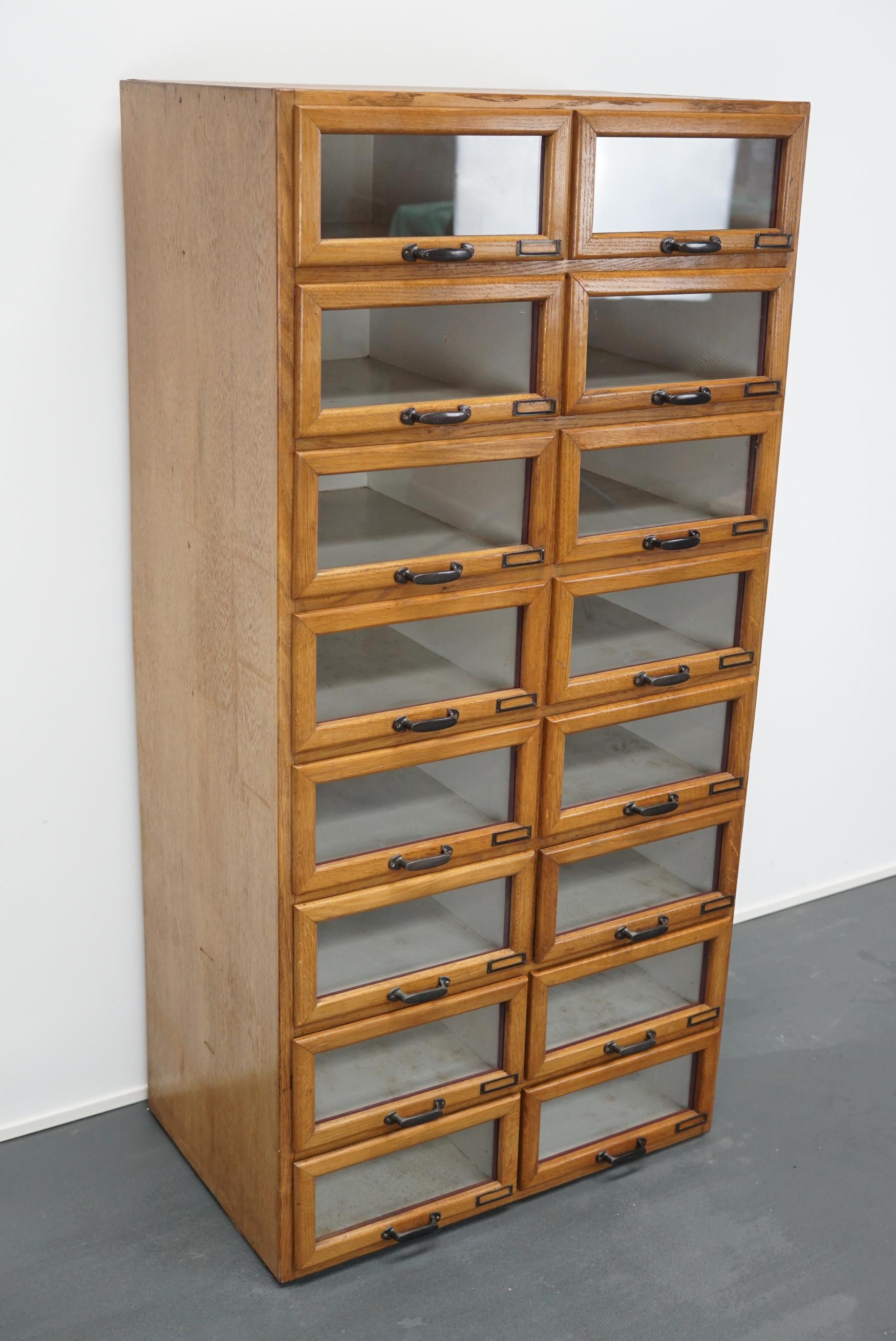 This vintage haberdashery shop cabinet originates from the Netherlands. The piece is made from oak and features 16 drawers which measure 42 x 30 x 14 cm on the inside.