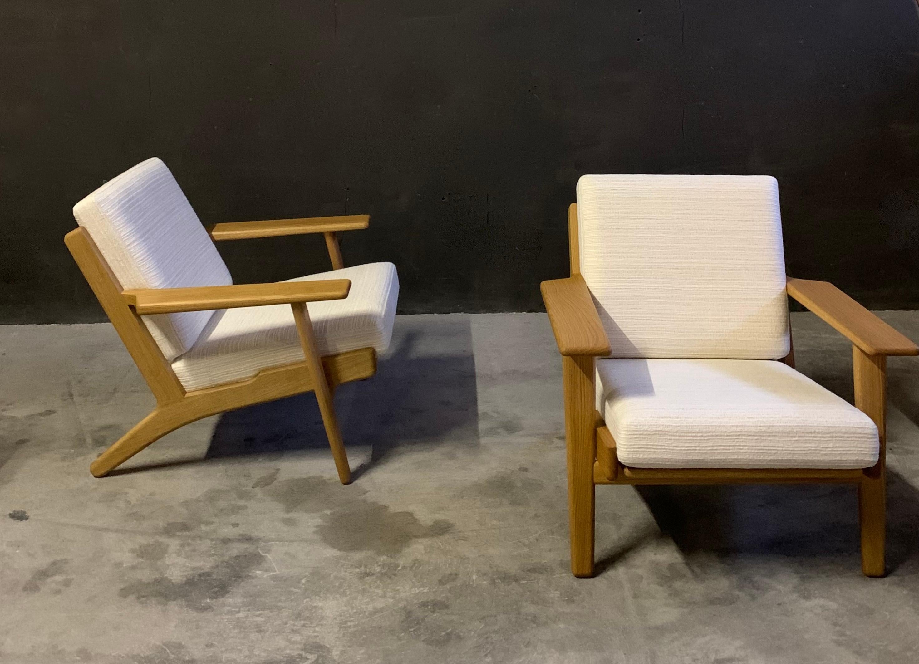 GE290 lounge chair by Hans J. Wegner, GETAMA, Denmark. Pair available, listed individually. Solid oiled oak frames, loose cushions upholstered in a premium off-white handwoven bespoke fabric. Sample available upon request. 
   
Lounge chair GE290 is