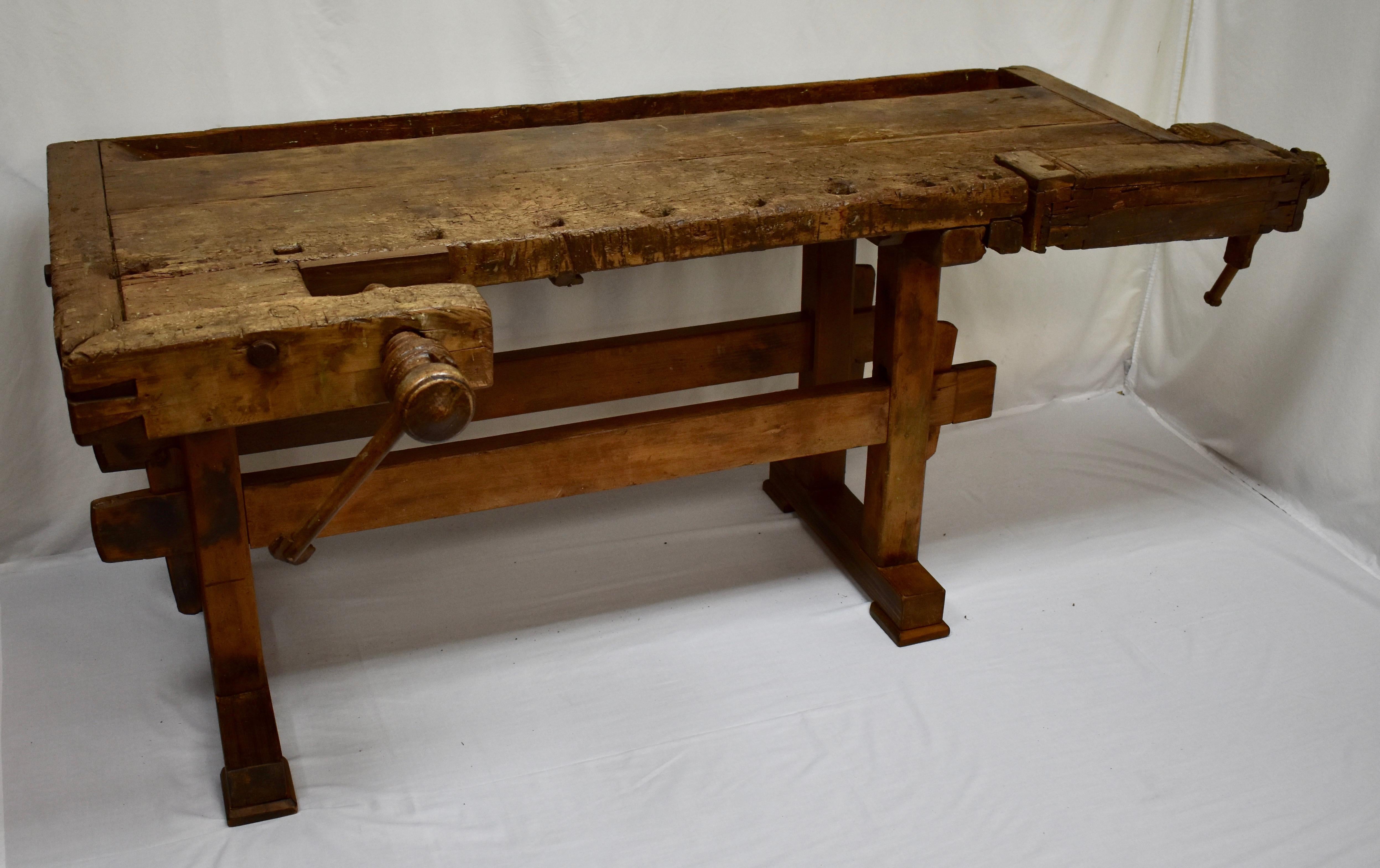 This is a magnificently gnarled joiner’s workbench, built as solid as a rock. The trestle-style base is made entirely of oak. The uprights are 3” square, hand-cut and chamfered on the corners, through-tenoned and pegged top and bottom to the