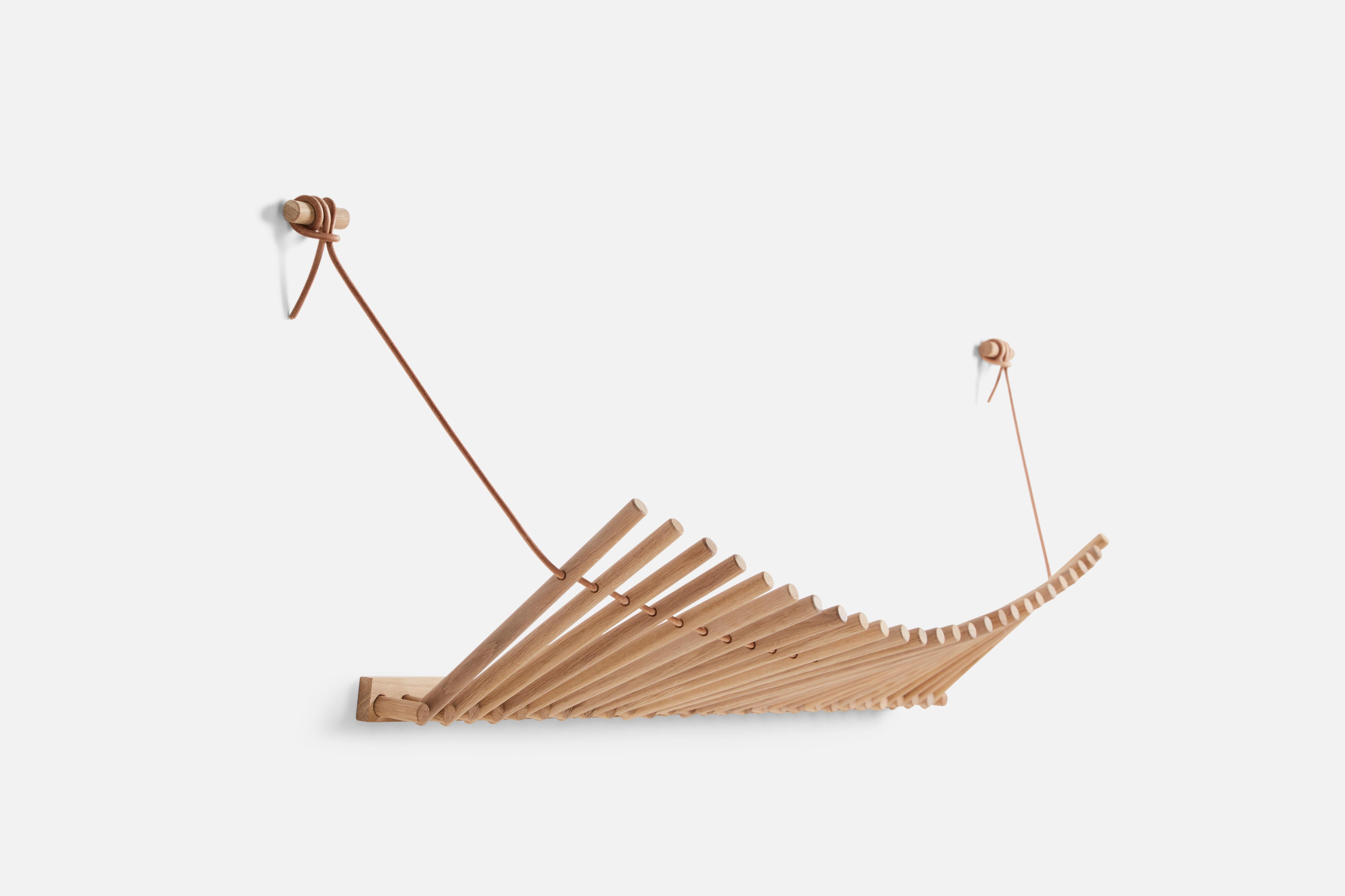 Oak Knaegt coat rack by Rikke Palmerston.
Materials: Oak, leather.
Dimensions: D 28.5 x W 87.5 x H 3.5 cm.
Available in oak or black oak.

Rikke Palmerston is a talented up-and-coming designer born in Denmark. A young designer focusing on