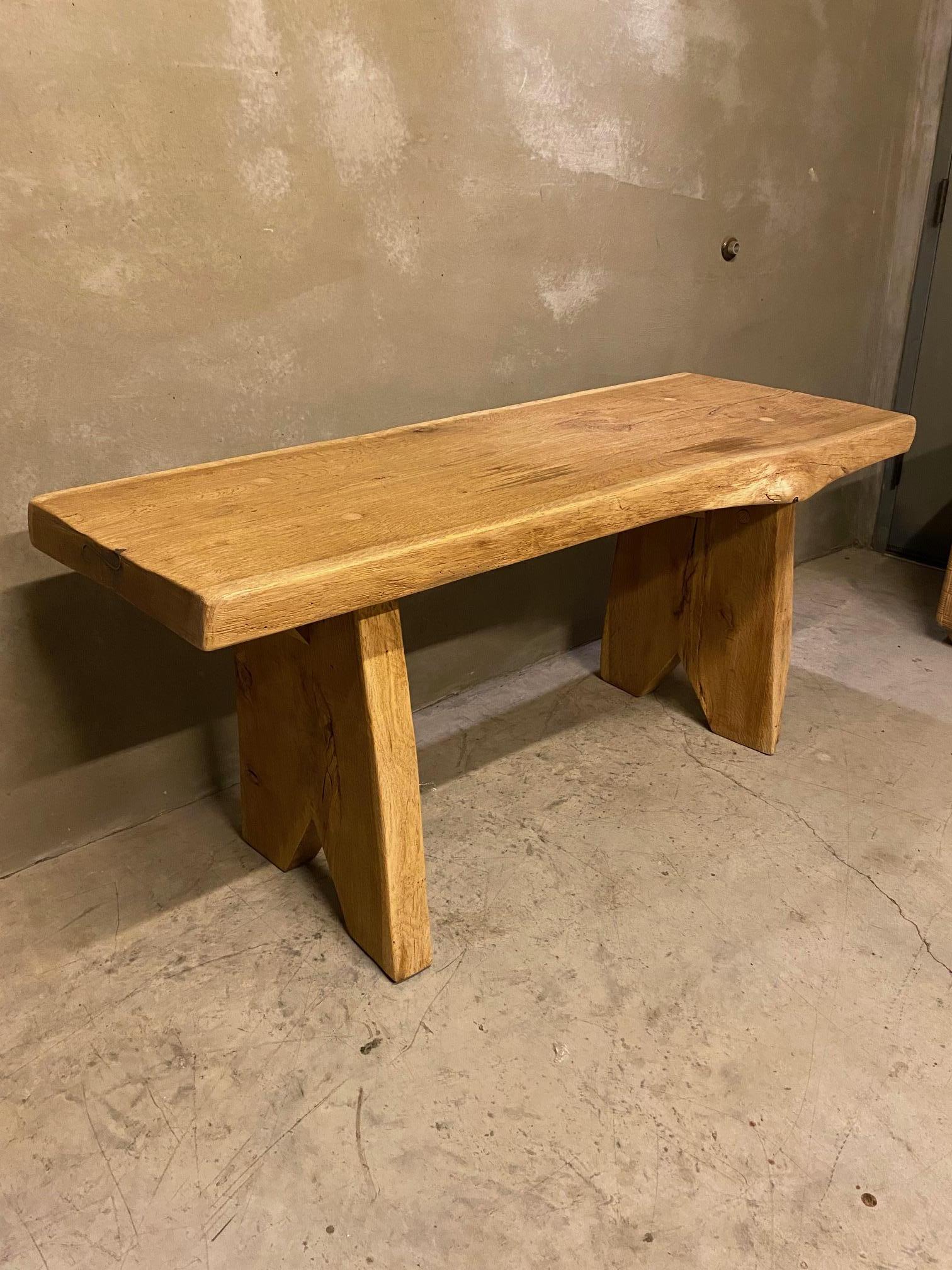 Brutalist, or mid-century modern, solid oak live edge console table or desk.  Thick oak slab top with organic shape supported by a pair of slab legs with an angular cut out detail on each.  End grain inset iron stabilizers are present on the left