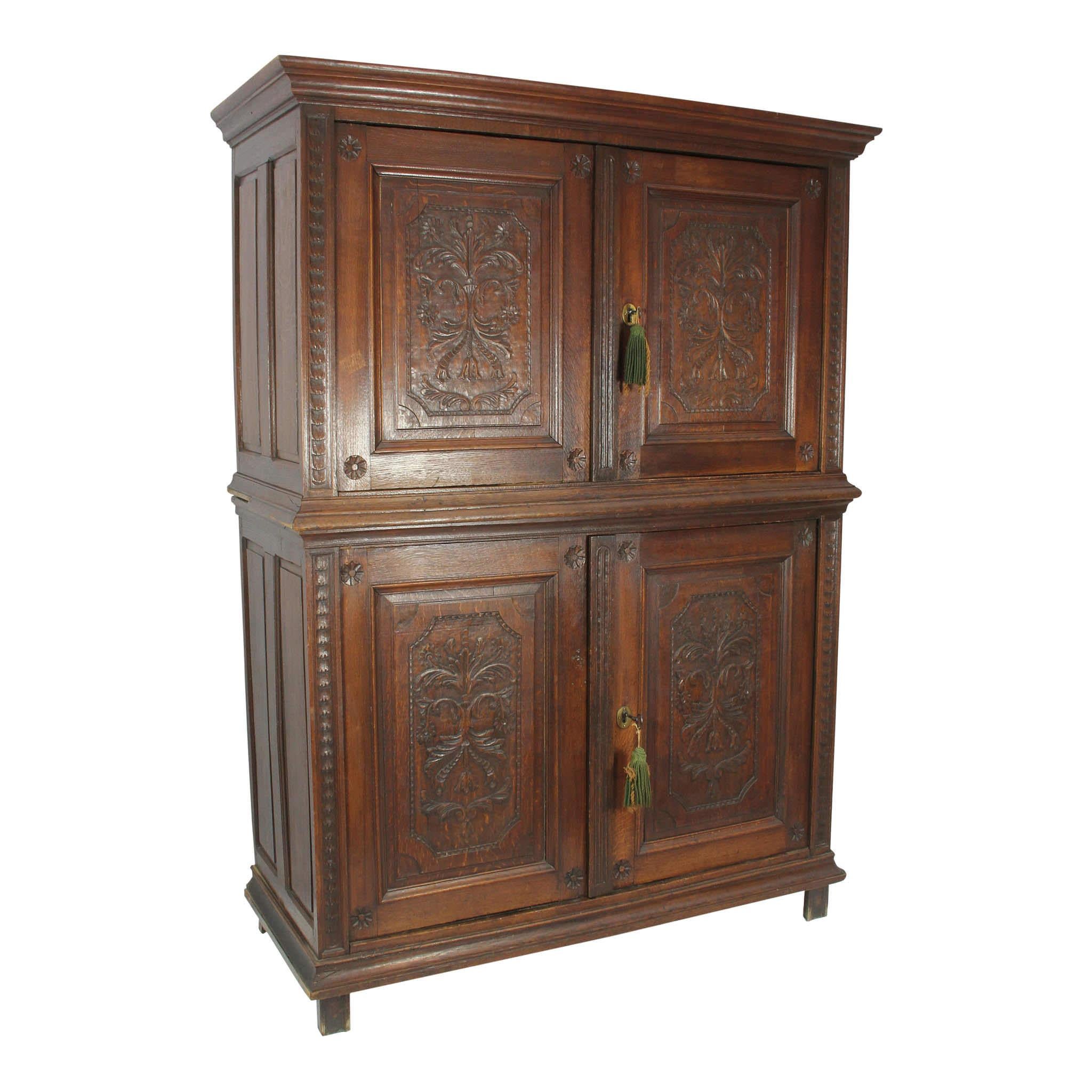 Storage abounds in this four-door cabinet with Louis XV style carvings on the doors. Both the top and bottom pair of doors open to double shelves. Crown molding at the top and raised panels on the sides add dimension to the piece. The cabinet stands