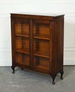 OAK LOW BOOKCASE WITH GLAZED DOORS ADJUSTABLE SHELVES AND CABRIOLE LEGS j1