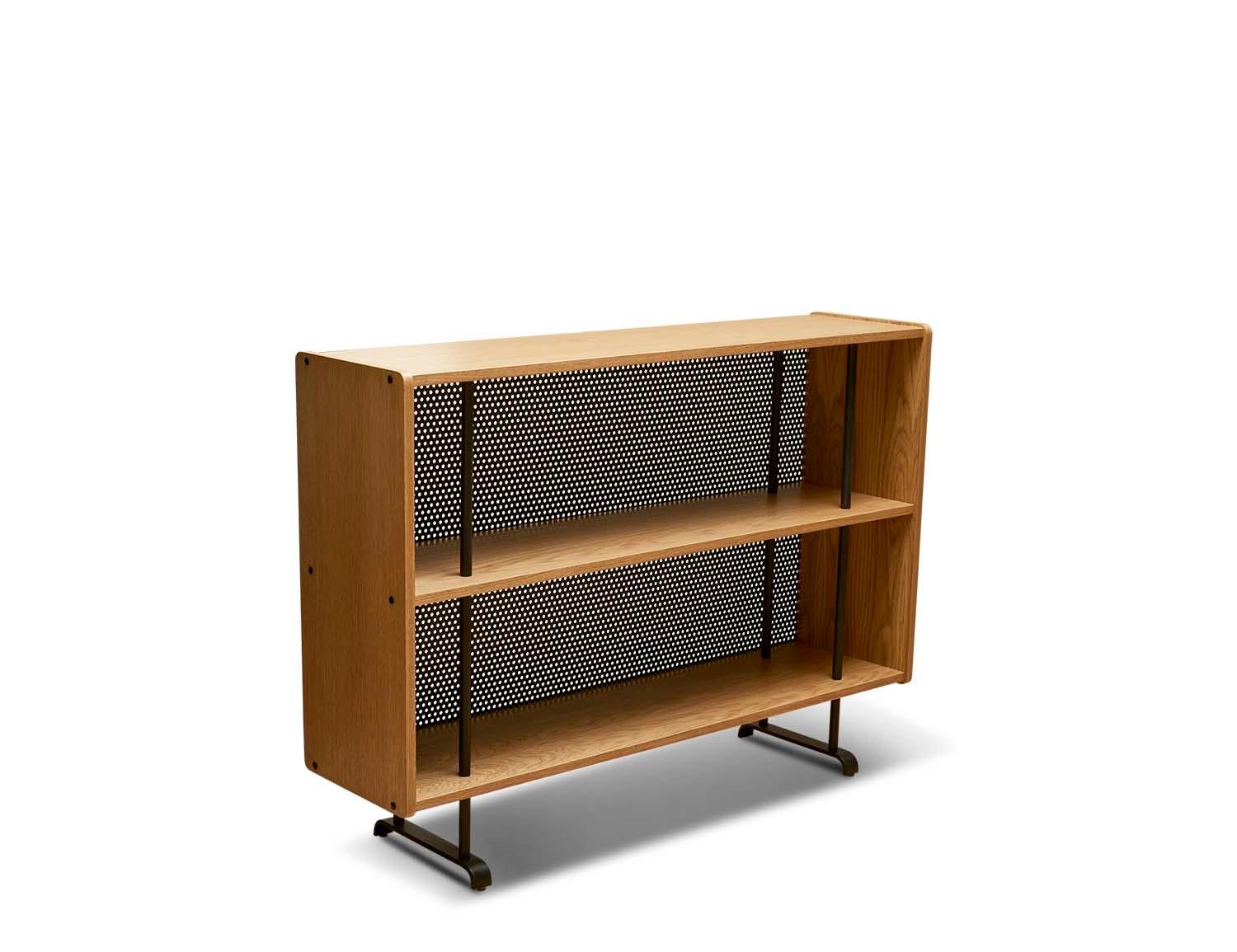 The Maker's bookcase is a freestanding bookcase made of American walnut or white oak. The frame rests on a blackened steel base and features two shelves and a perforated steel detail on the back. 

The Lawson-Fenning Collection is designed and