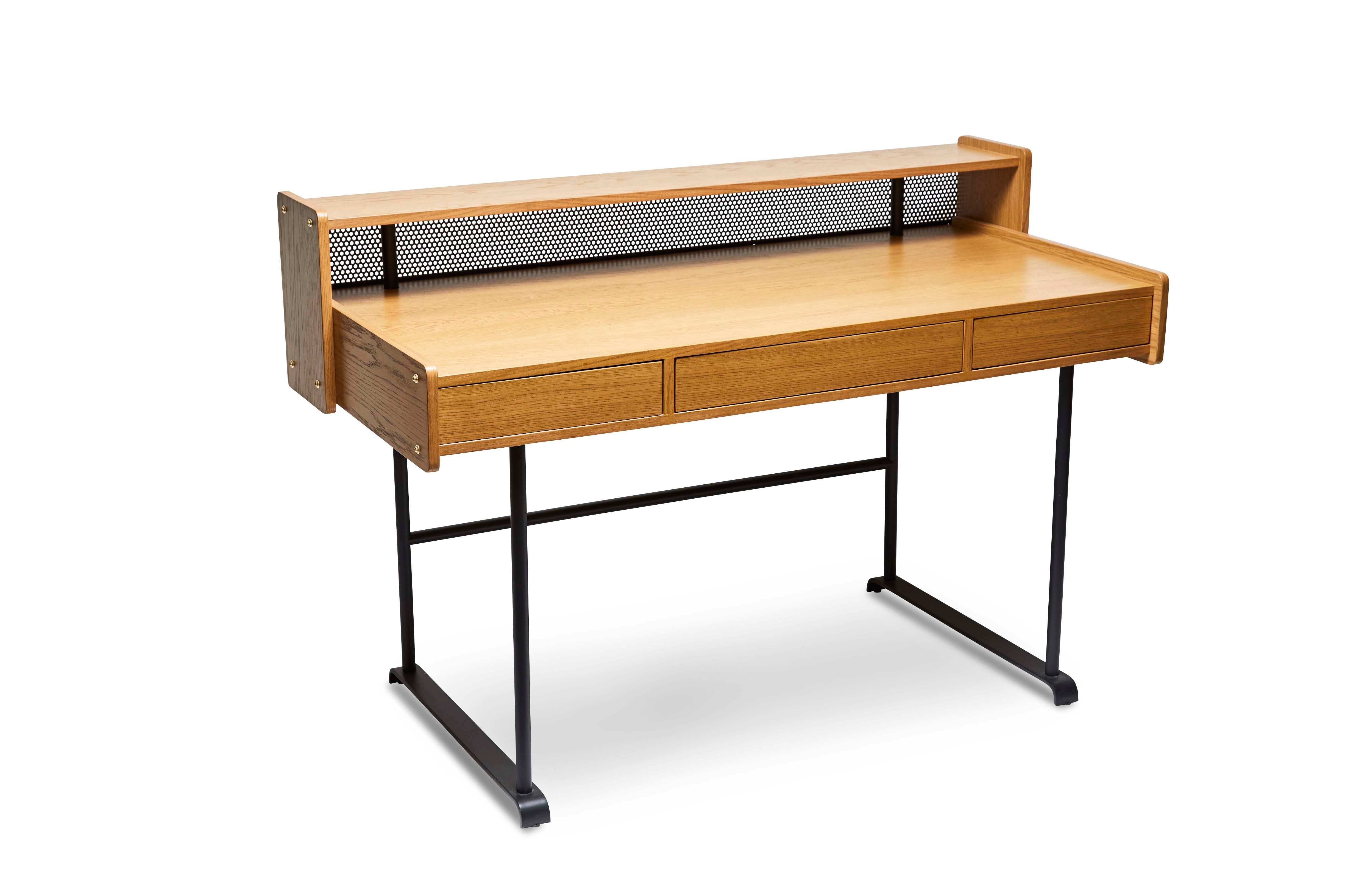 The Maker's desk is made of American walnut or white oak and has three push-to-open drawers. The case rests on a matte black powder-coated base, and features perforated steel detail on the back. Shown here in oiled oak.

The Lawson-Fenning