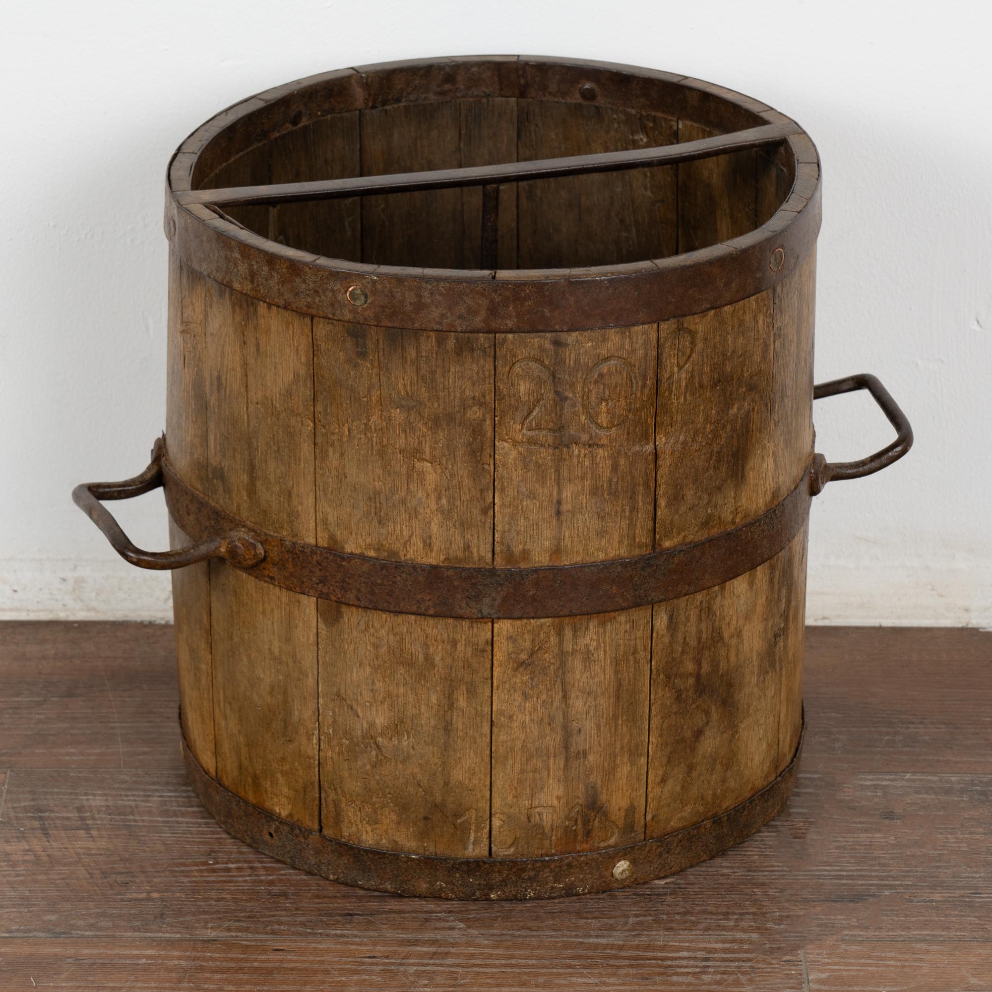 20 liter old oak measuring bucket with iron banding and handles. 
Iron cross bar and central rod that connects cross bar to bottom of bucket interior. 
In stable, waxed condition.
Any scratches, cracks, dings, or age related separation are