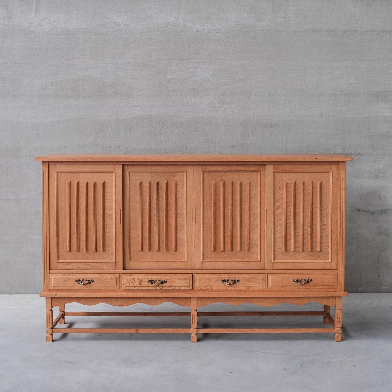 
A slight oak slatted door cabinet or sideboard in the manner of Henning Kjaernulf. 

Denmark, c1960s. 

Four doors with shelves raised over four doors. 

Good vintage condition. 

Location: Belgium Gallery. 

Dimensions: 120 H x 200 W x 45 D in cm.