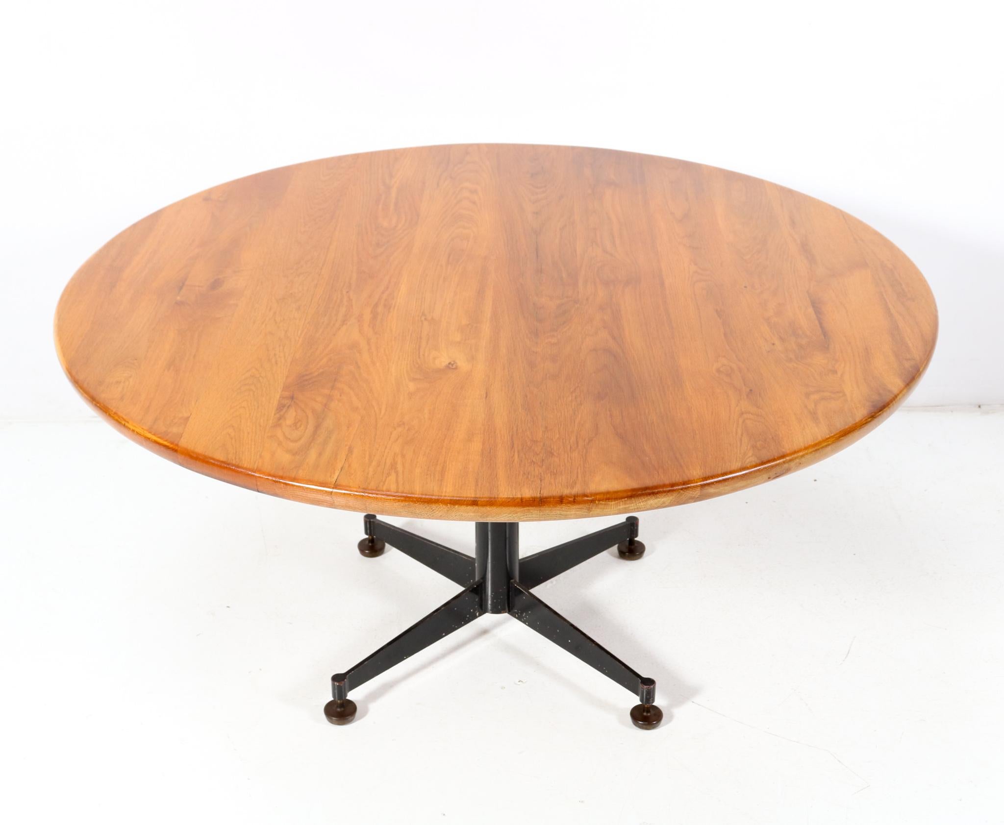 Magnificent and one of a kind Mid-Century Modern round dining room table.
Design by Architect Bart van Kasteel.
Striking Dutch design from the 1960s.
Original grey lacquered steel base with original round solid oak table top.
Comes with the original