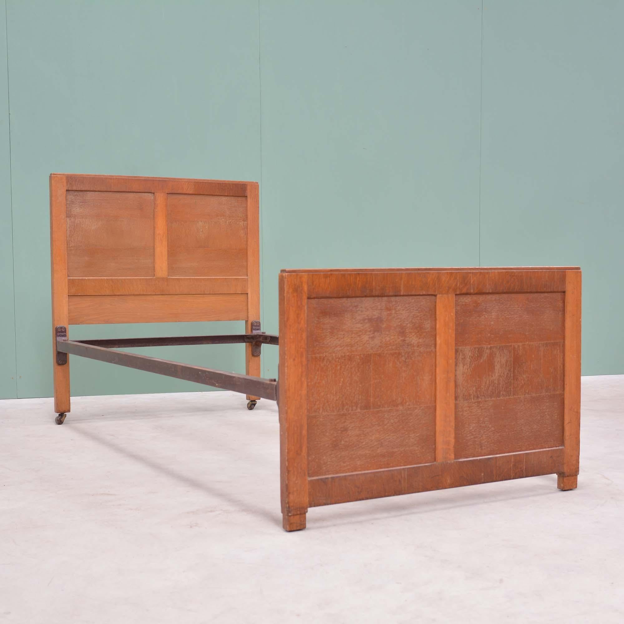 Oak single bed in the manner of Heals
By A.B. Ltd, 'Good Furniture Units' who took their inspiration from Heals producing good quality household furniture, label to headboard.  Head and foot boards panelled in quarter sawn oak, supported by iron