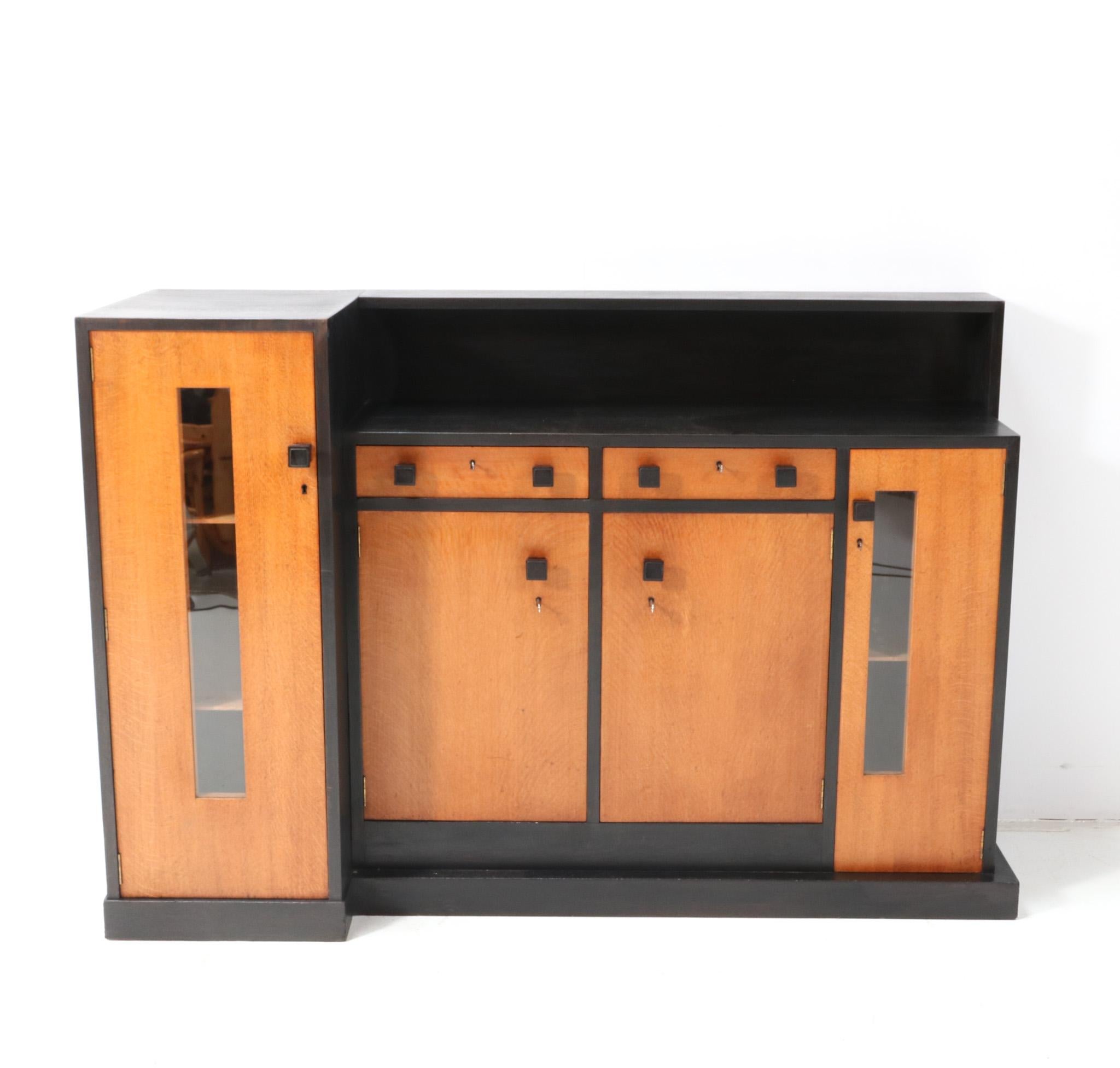 Magnificent and ultra rare Modernist Art Deco sideboard or credenza.
Design by Cor Alons and executed by Fa. Winterkamp & Van Putten in 1927.
Striking Dutch design from the 1920s.
Solid oak and black lacquered base with original black lacquered