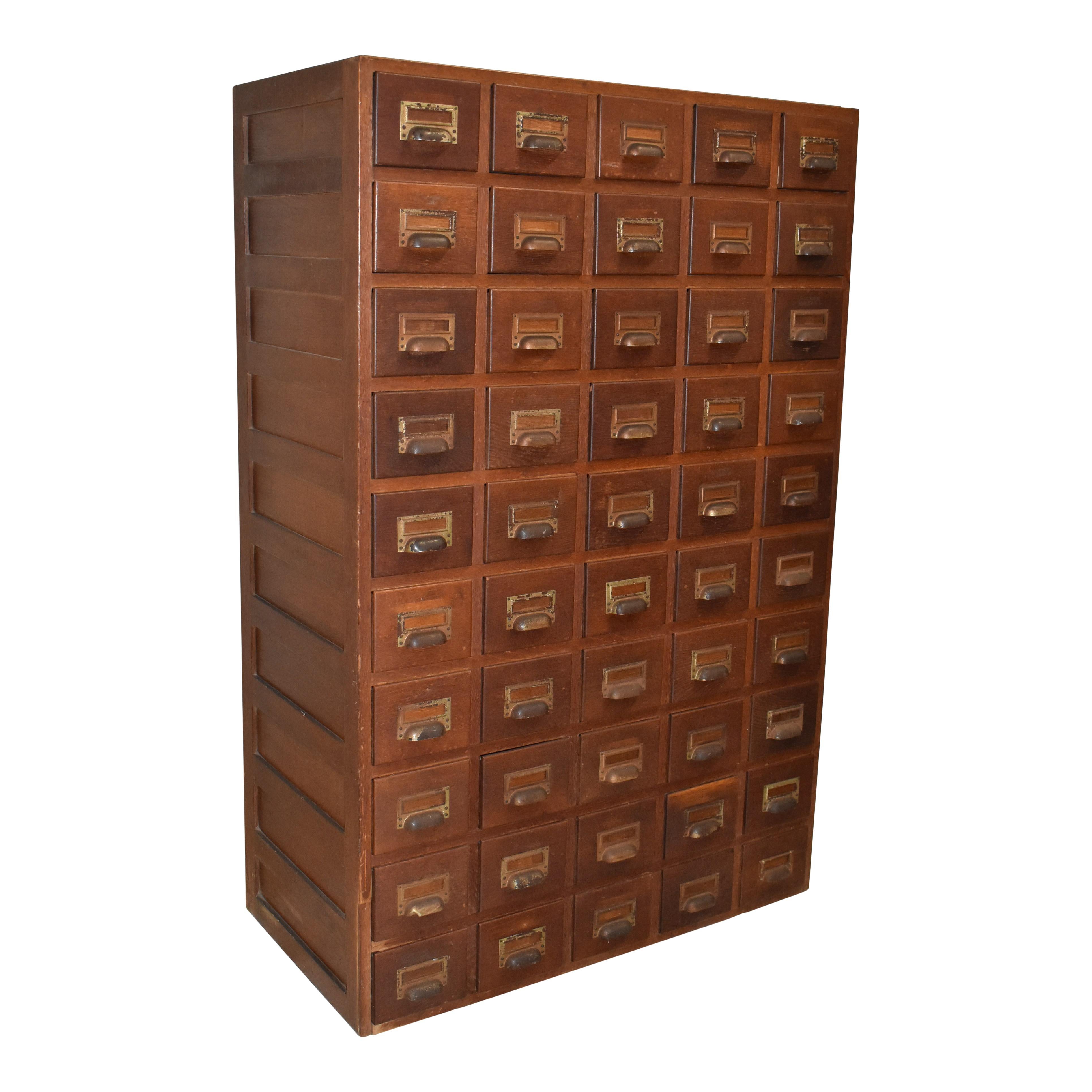 Rappelant l'époque où les bibliothèques ne suivaient pas leurs sélections à l'aide de systèmes informatiques, ce meuble à tiroirs multiples en chêne est composé de 50 tiroirs à catalogues dotés d'une quincaillerie réglable permettant de maintenir